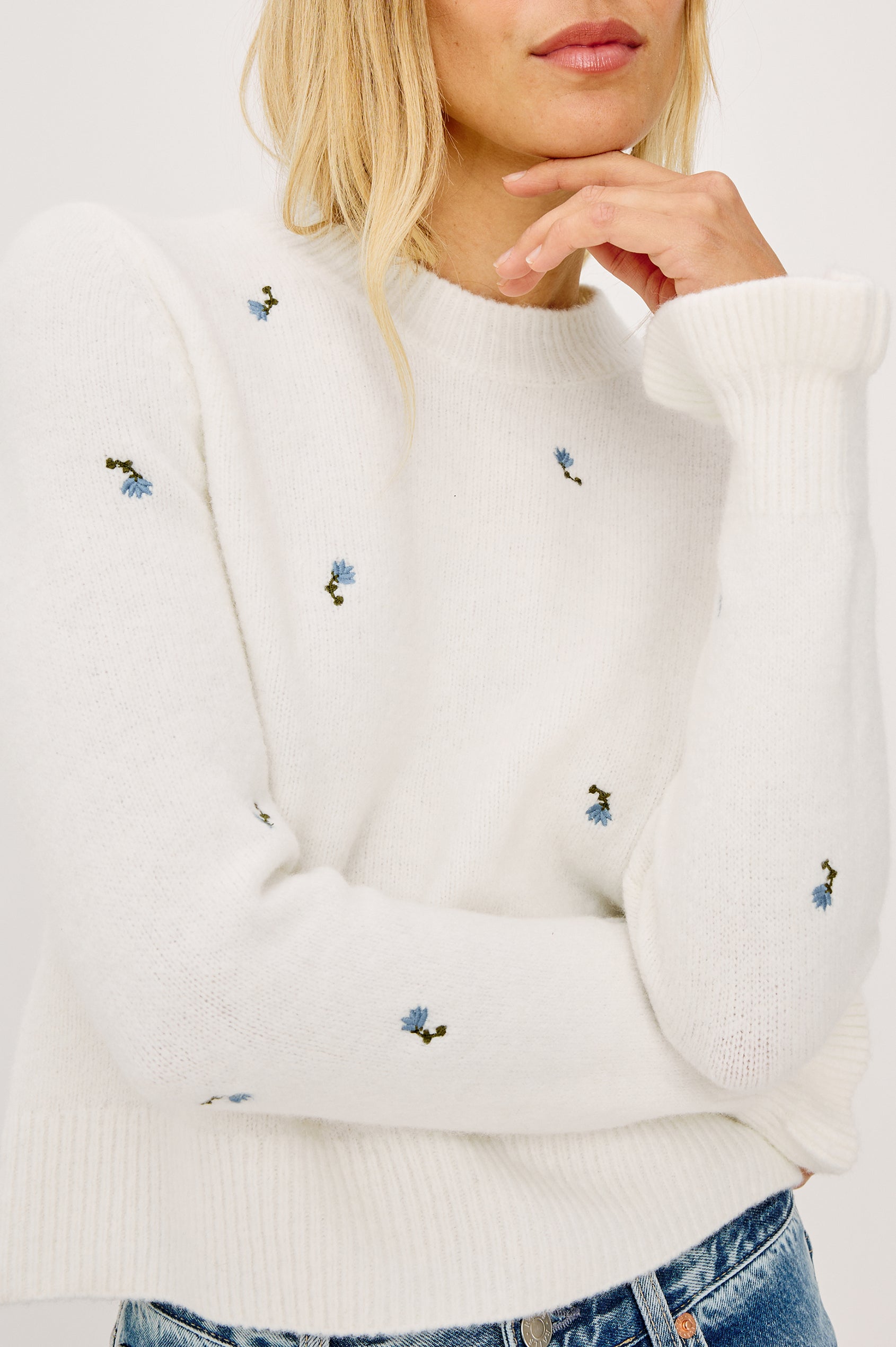 Bettie Sweater in Soft Wool Blend With Crew Neck, Long Sleeves With Ruffled Cuffs, Ribbed Trim, and Floral Embroidery in Blue Buds Colorway - Upper Body Front View Featured on Model