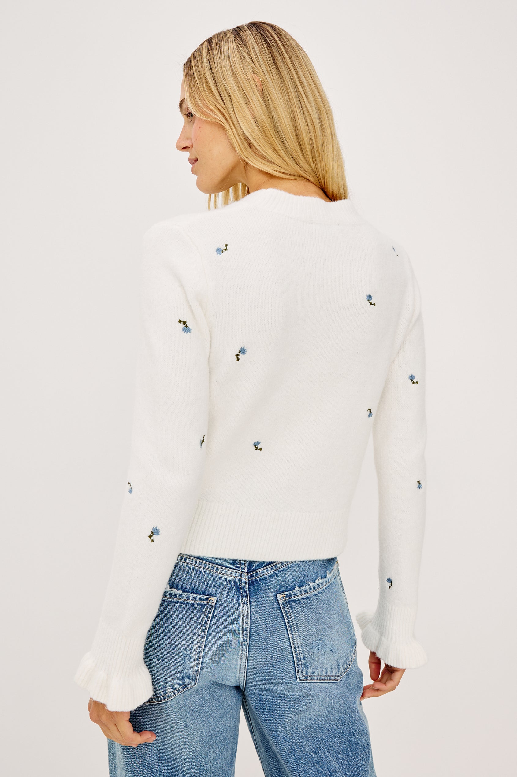 Bettie Sweater in Soft Wool Blend With Crew Neck, Long Sleeves With Ruffled Cuffs, Ribbed Trim, and Floral Embroidery in Blue Buds Colorway - Upper Body Back View Featured on Model