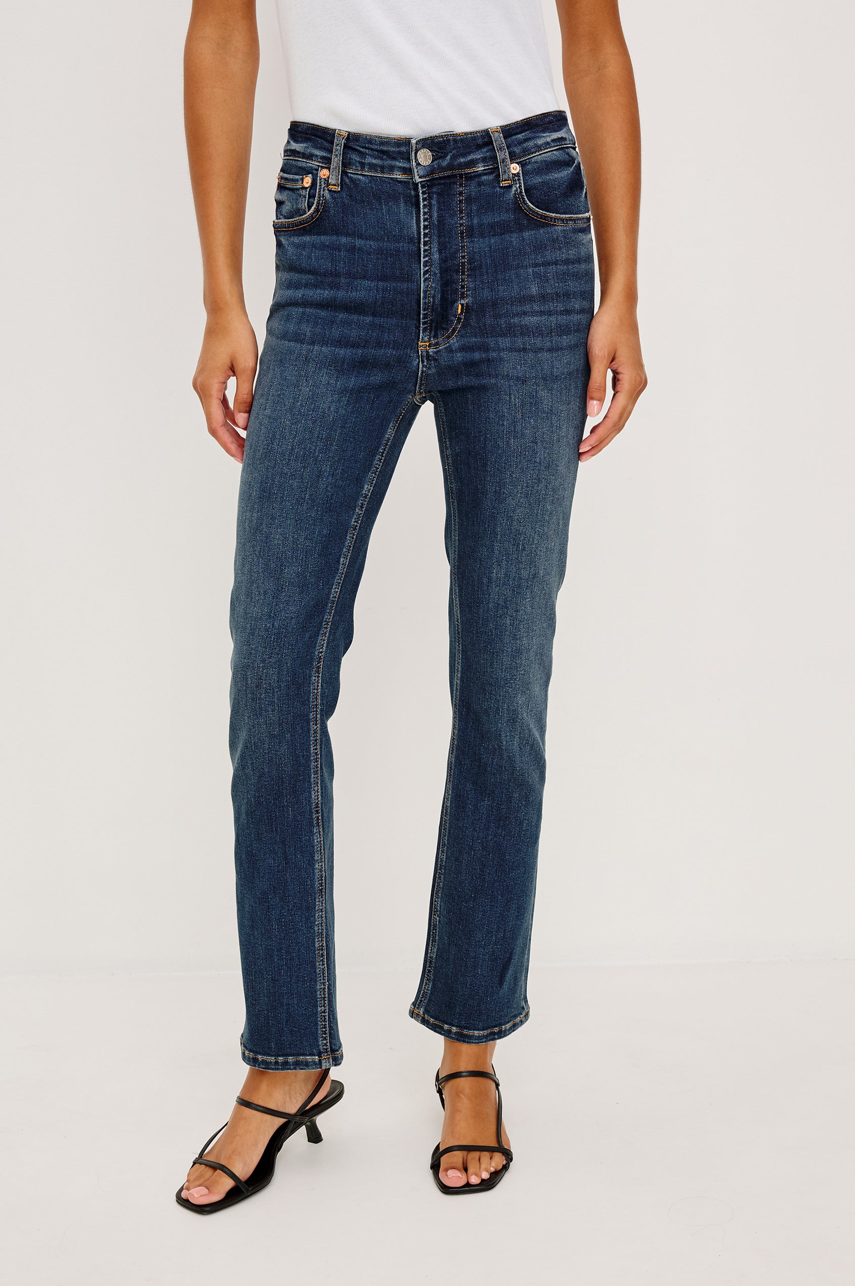 Bixby Mid-Rise Slim Straight Jean in High Stretch Denim With 25″ Inseam, Zip Fly, and 5-Pockets in Deep Dive Colorway - Lower Body Front View Featured on Model