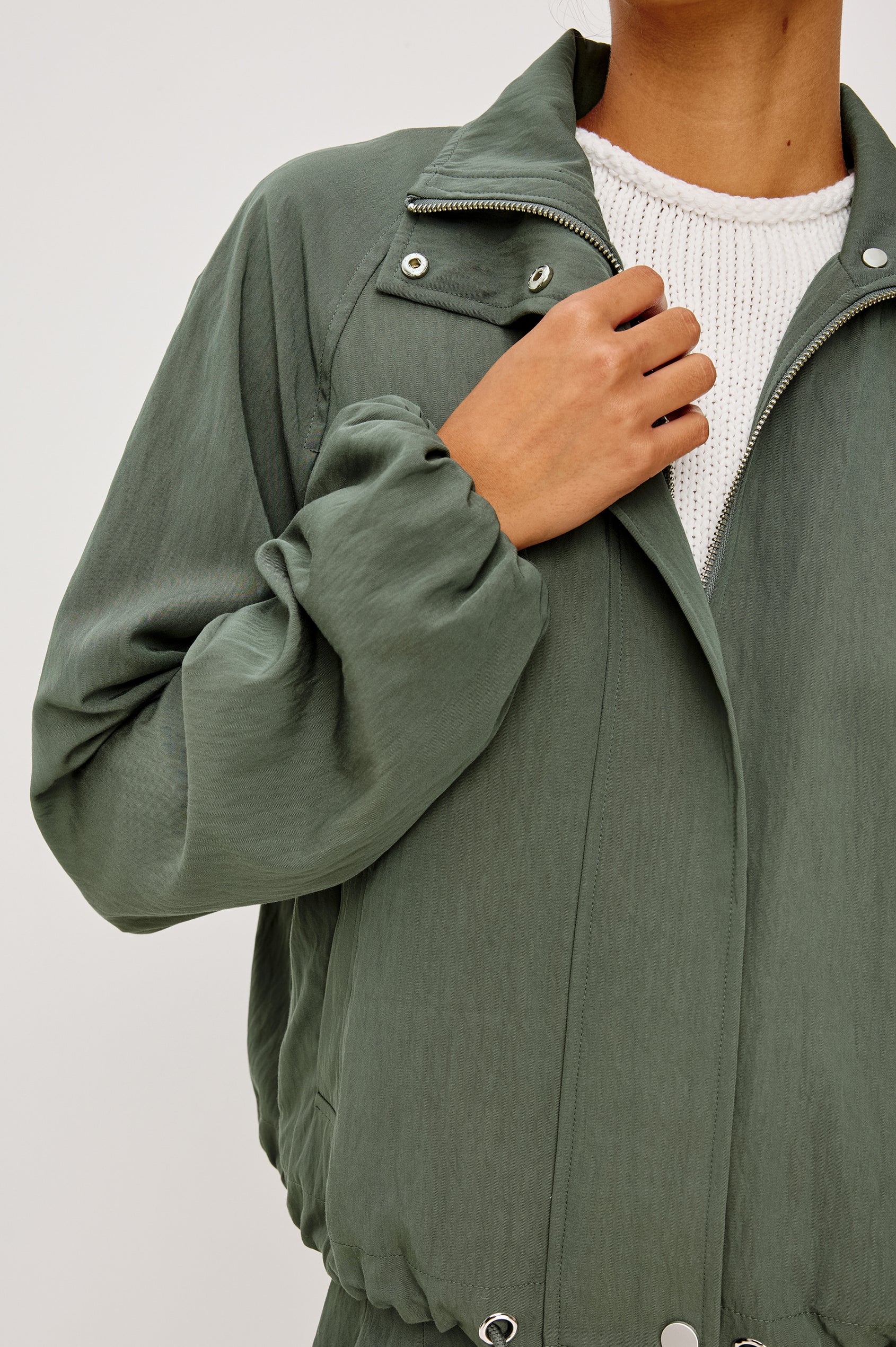 Black Jacket With Oversized Relaxed Fit, High Funnel Neck, Dropped Shoulders, Long Sleeves, Center-Front Ties, Side-Seam Zipper in Ivy Colorway - Upper Body Front Close Up View Featured on Model