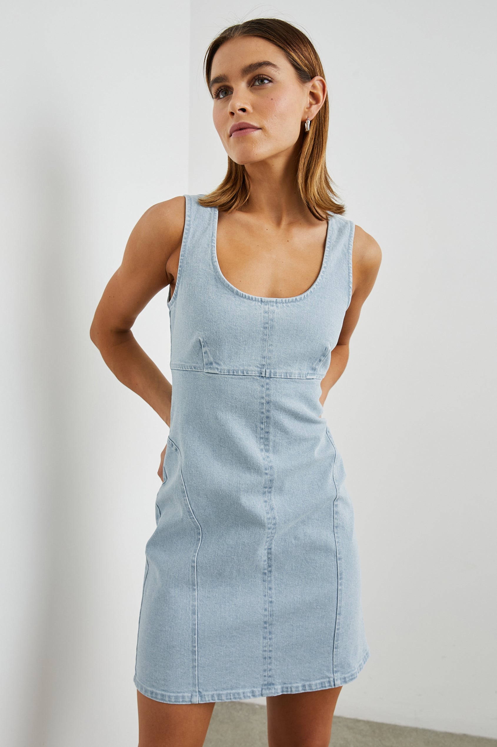 Blaze Denim Sleeveless Mini Dress with a Scoop Neck, Wide Shoulder Straps, a Full Zipper Back Closure, and Additional Seams in Bleach Indigo Colorway - Front View Featured on Model 