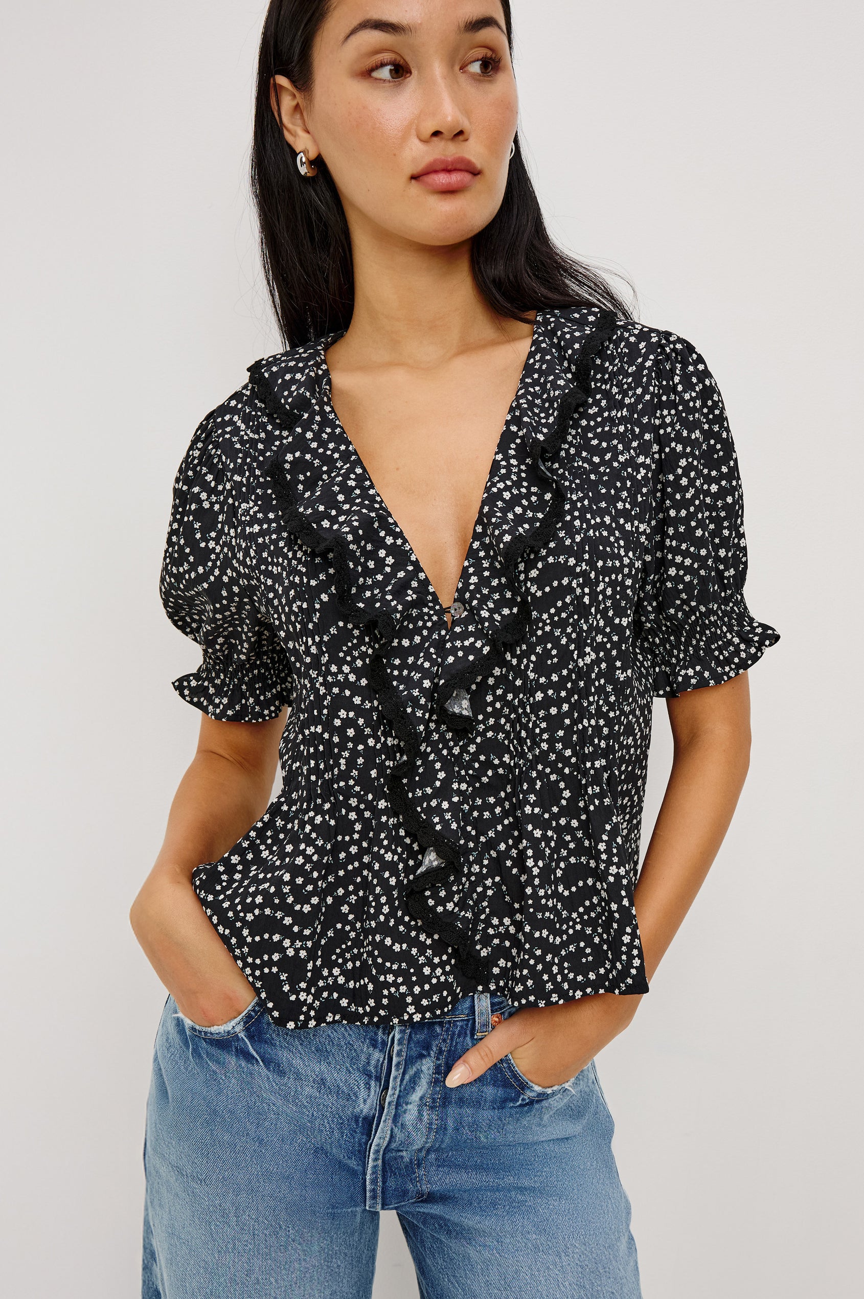 Bloom Poplin Top With Ruffle V-Neckline, Elbow-Length Puff Sleeves With Ruffled Cuffs, Pintuck Detailing, and Boxy Relaxed Fit in Mini Chain Daisies Colorway - Upper Body Front View Featured on Model
