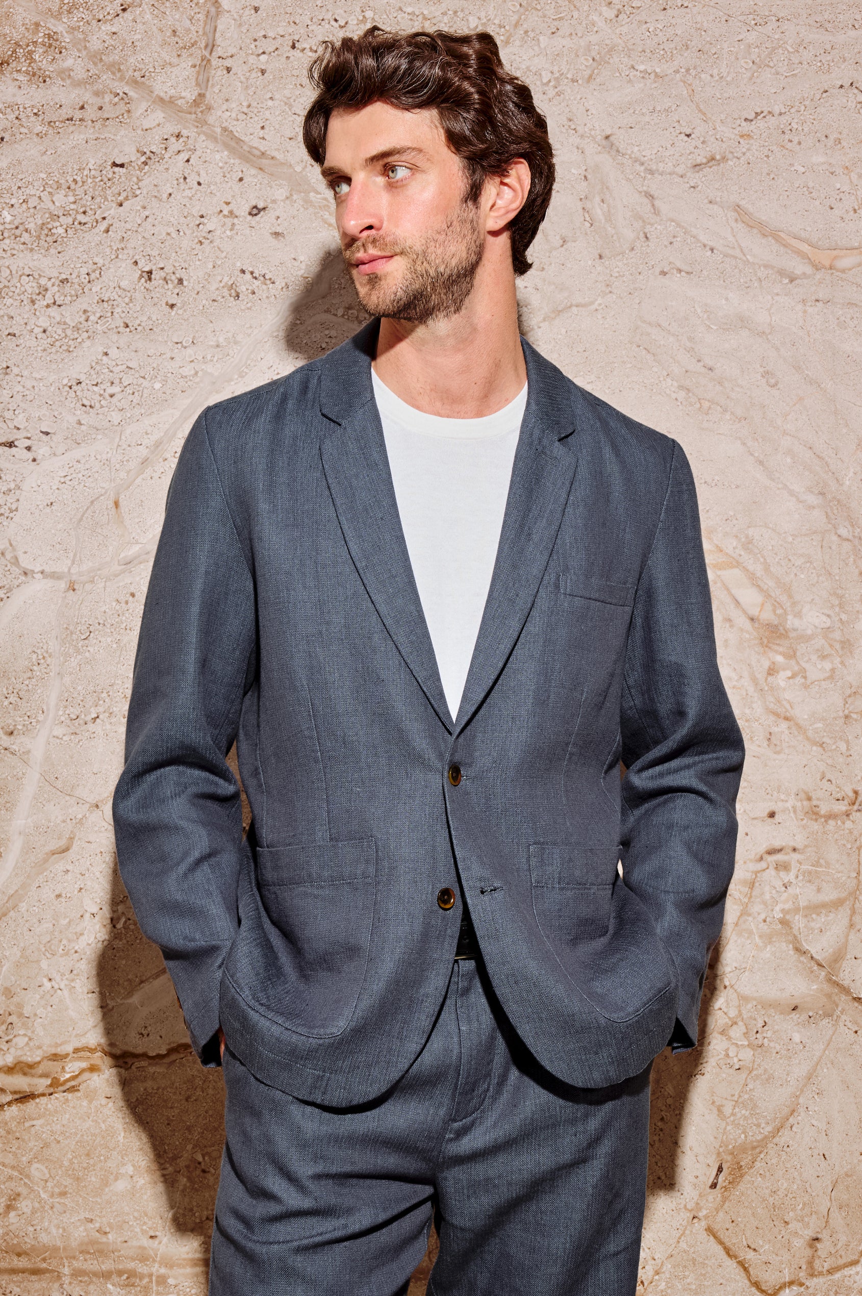 The Bond is a single breasted blazer with two buttons, one chest pocket and two patch pockets in a blue Meridian colorway. Front view featured on model.