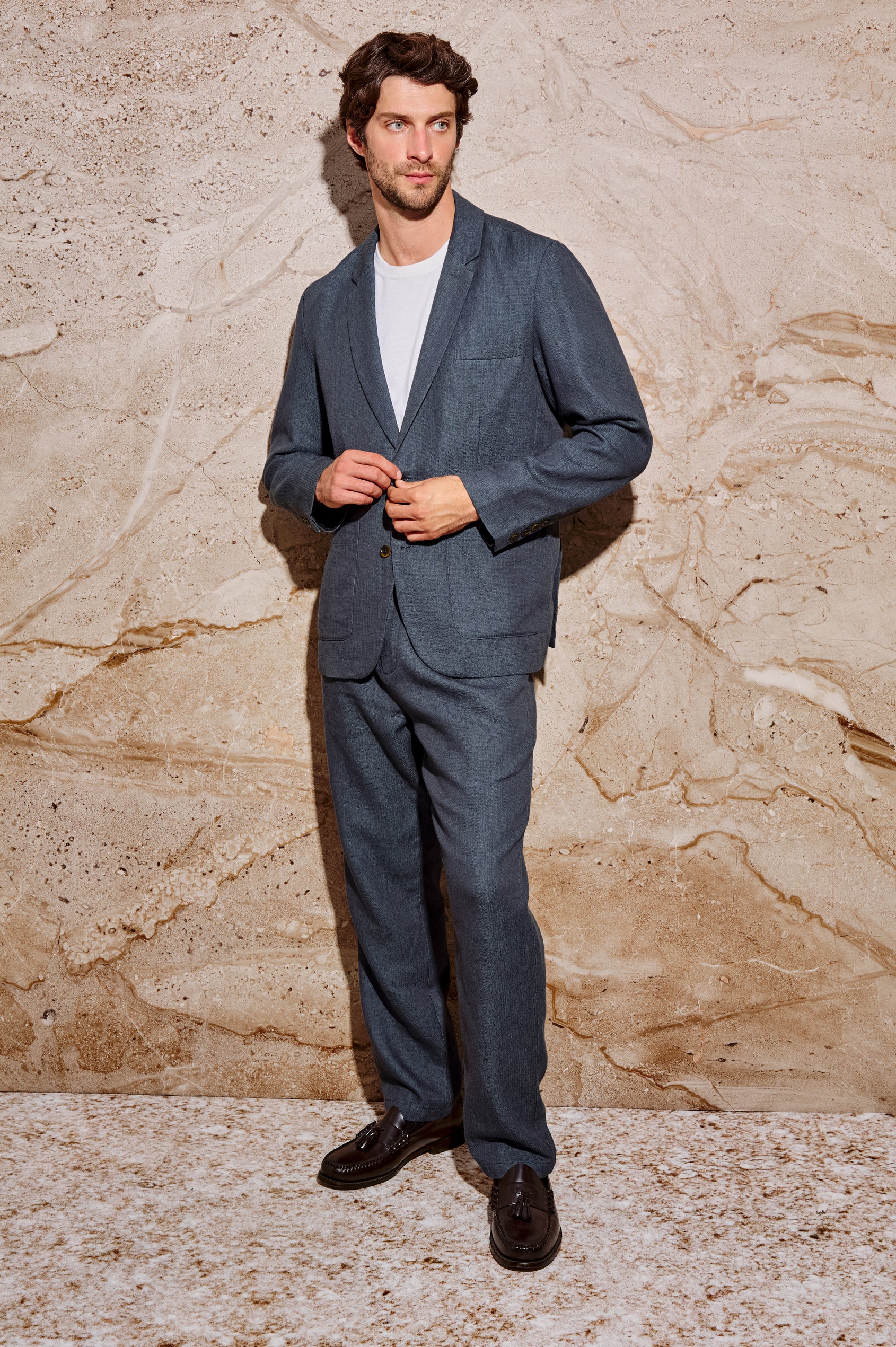 The Bond is a single breasted blazer with two buttons, one chest pocket and two patch pockets in a blue Meridian colorway. Front full body view featured on model.