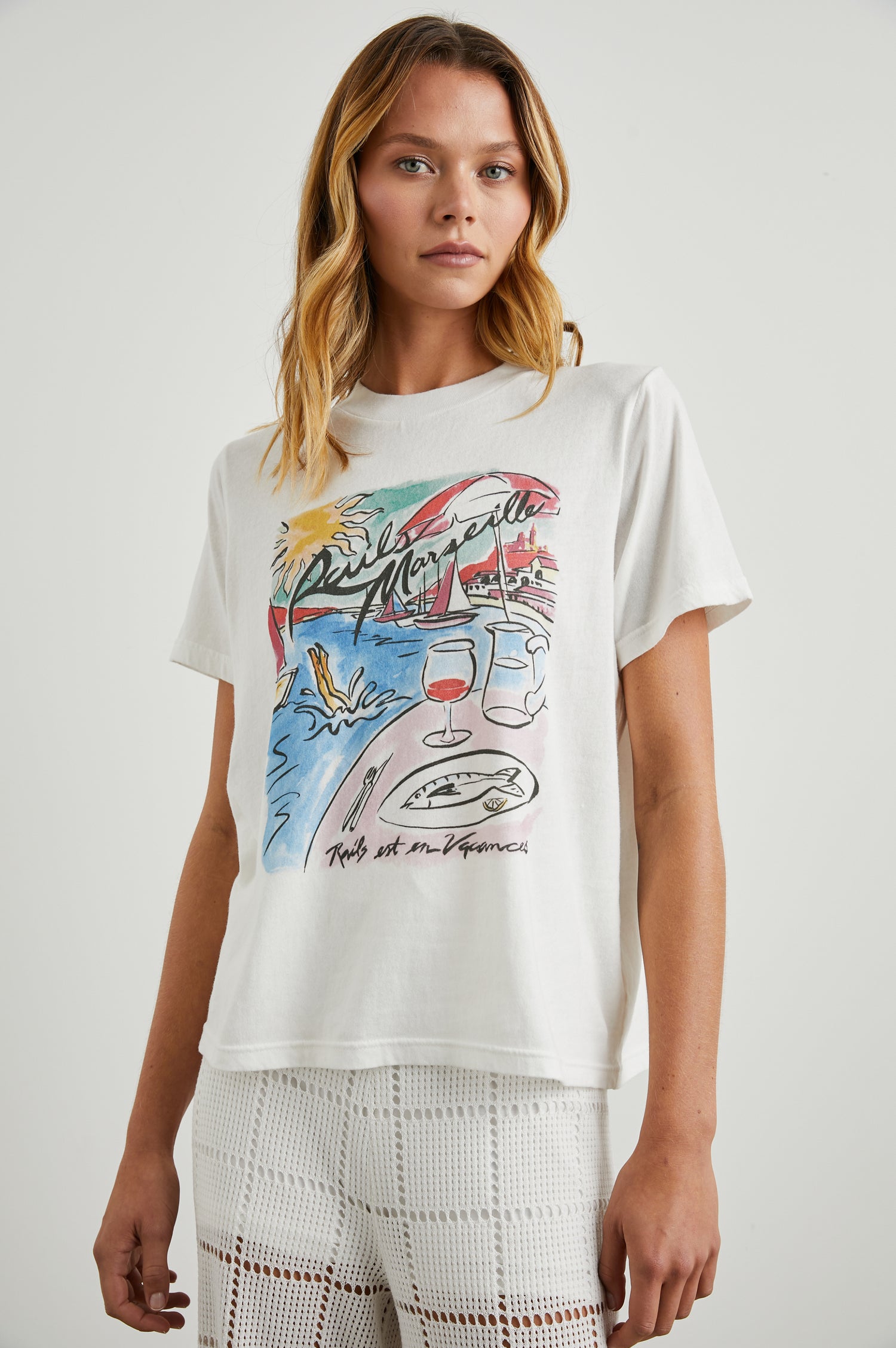 Boyfriend T-Shirt with a Crew Neck, a seaside image and the text, Rails Marseille Rails et en Vacances in Rails Marseille Colorway, with text and image in black and pinks on a White shirt - Front View Featured on Model