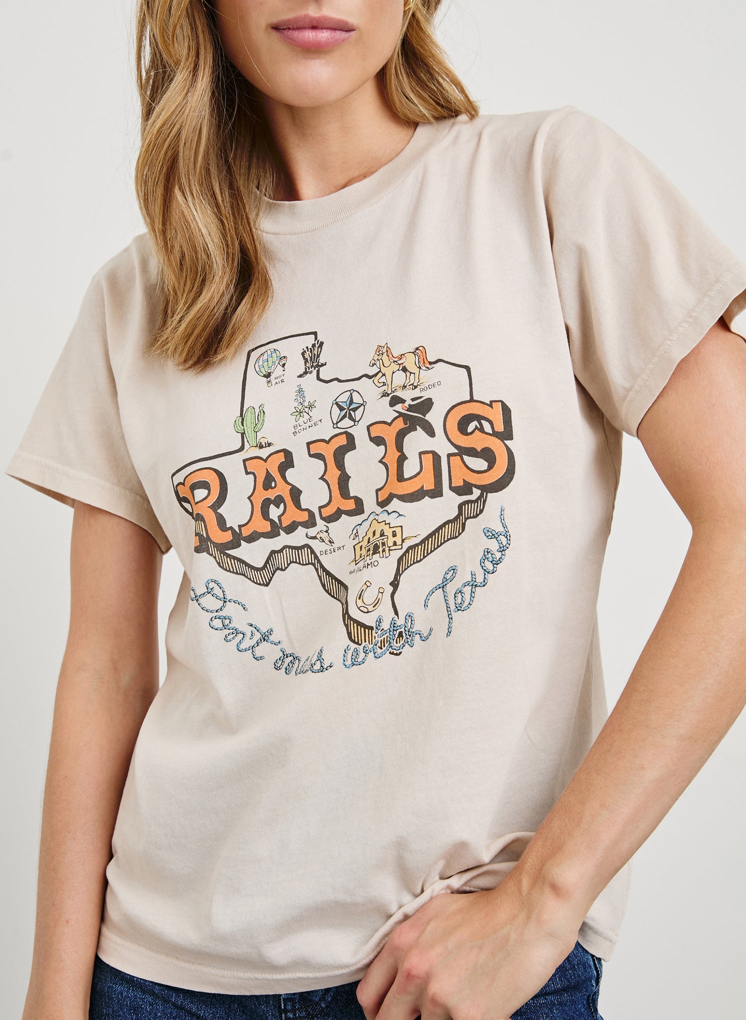Boyfriend T-Shirt with a Crew Neck, Texas images, and the text, Texas, Don't Mess with Texas in Rails Texas Colorway, with text in orange and blue on Tan - Front View Featured on Model