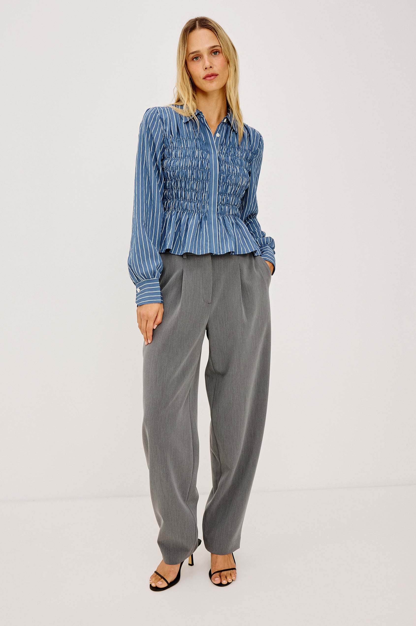 Bradshaw Shirt in Cotton Poplin With Button-Up Front, Collar, Smocked Body, Peplum Hem, and Bishop Sleeves in Washed Indigo Stripe Colorway - Full Body Front View Featured on Model