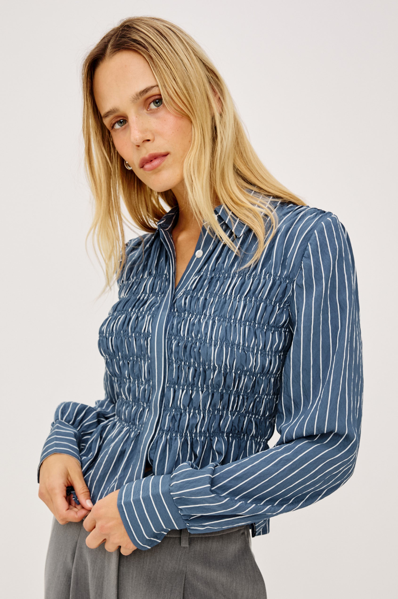 Bradshaw Shirt in Cotton Poplin With Button-Up Front, Collar, Smocked Body, Peplum Hem, and Bishop Sleeves in Washed Indigo Stripe Colorway - Upper Body Front View Featured on Model