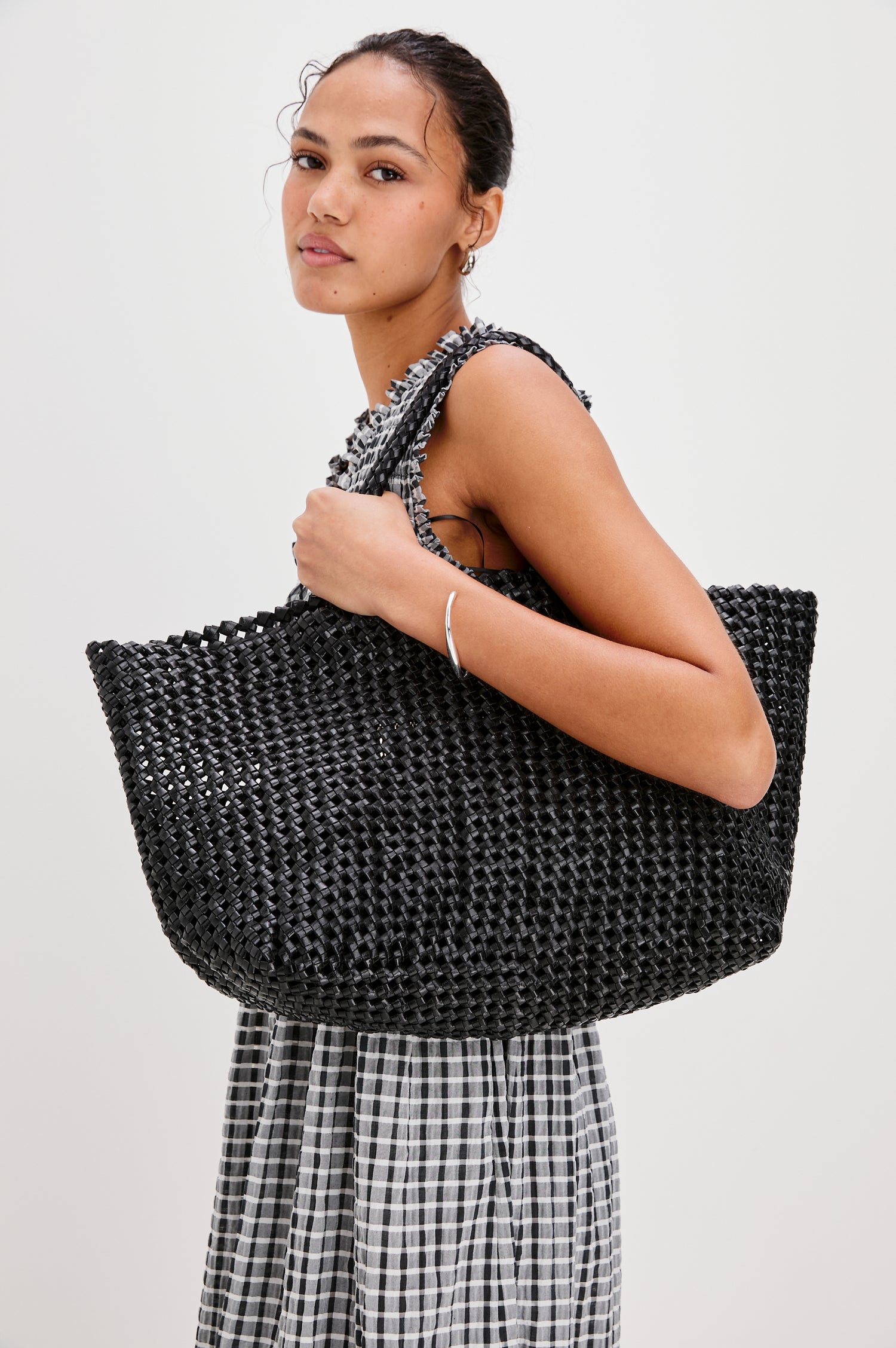 Brava oversized woven tote bag in Black - view of model holding bag at side on shoulder