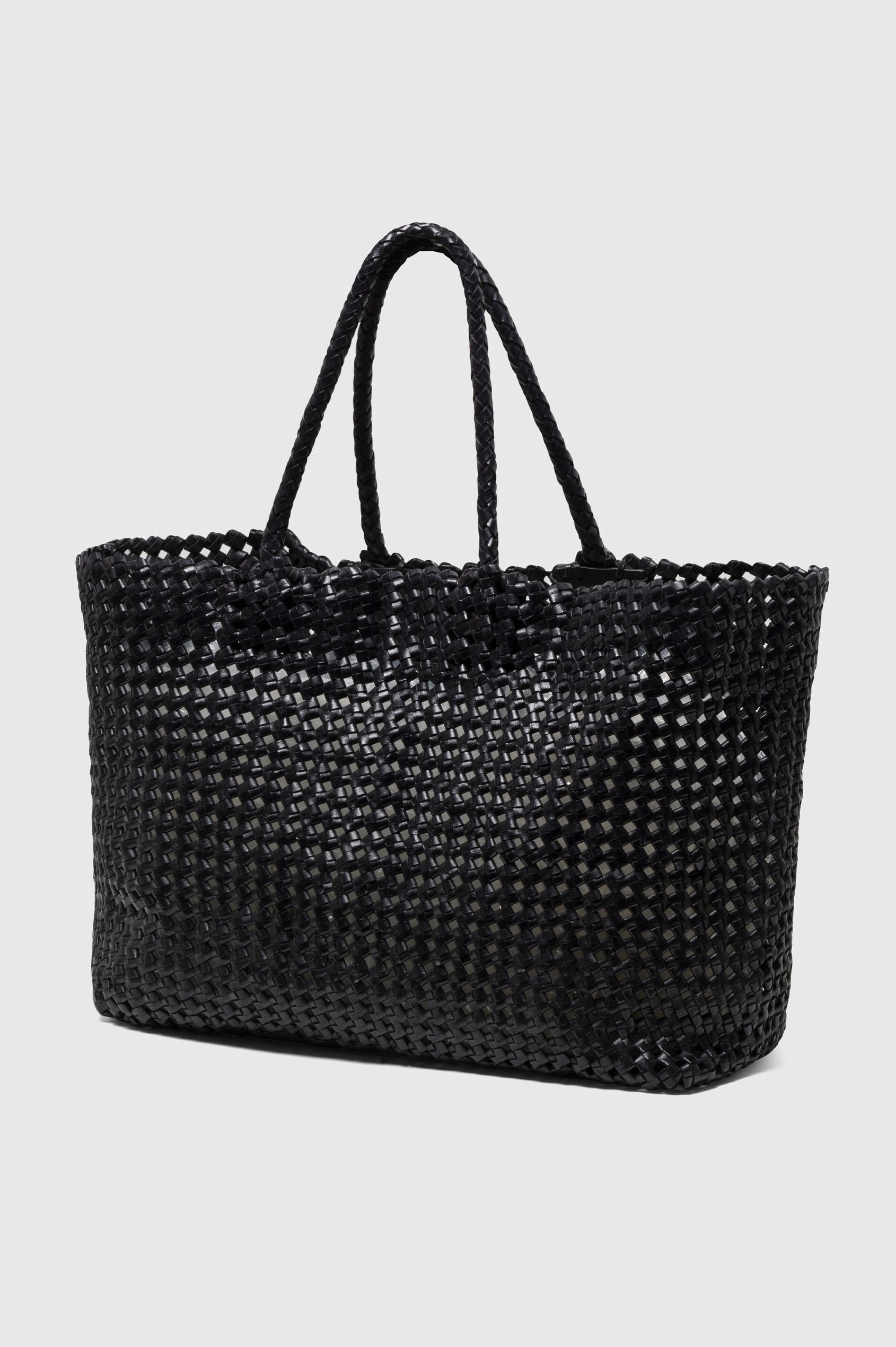 Brava Tote in Woven Leather With Top Handles and Spacious Interior in Black Colorway - angeled view off model