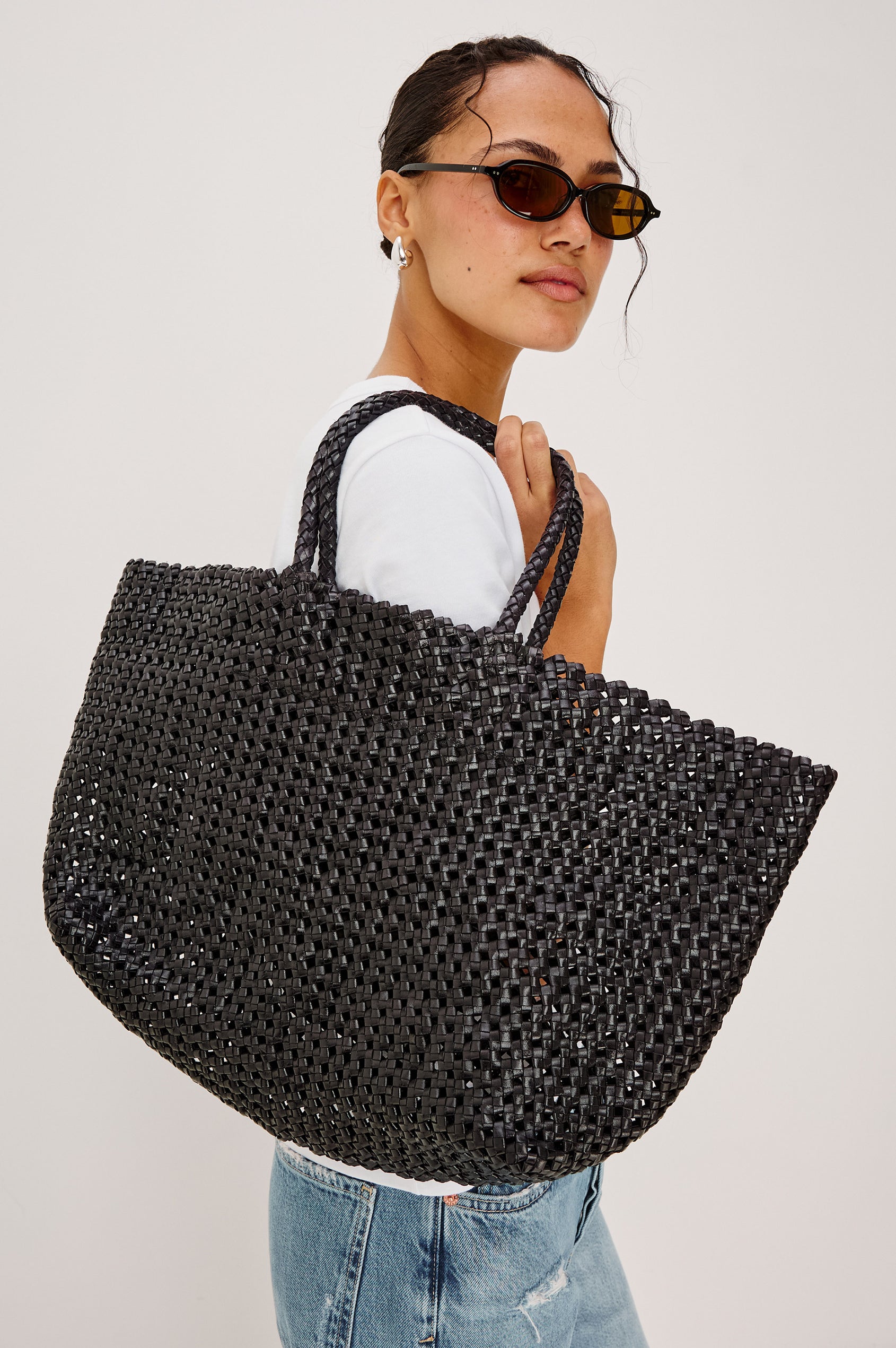 Brava oversized woven tote bag in Black - view of model holding bag on shoulder