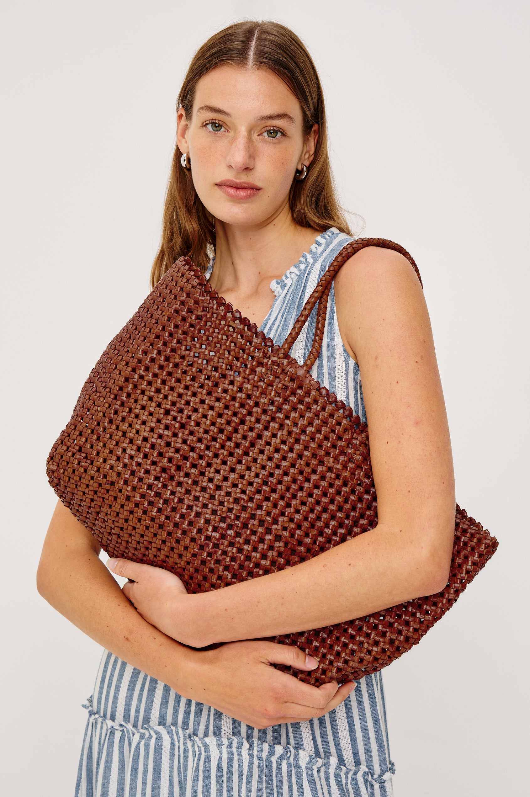 Brava oversized woven tote bag in Cognac brown - front view of model with bag over shoulder