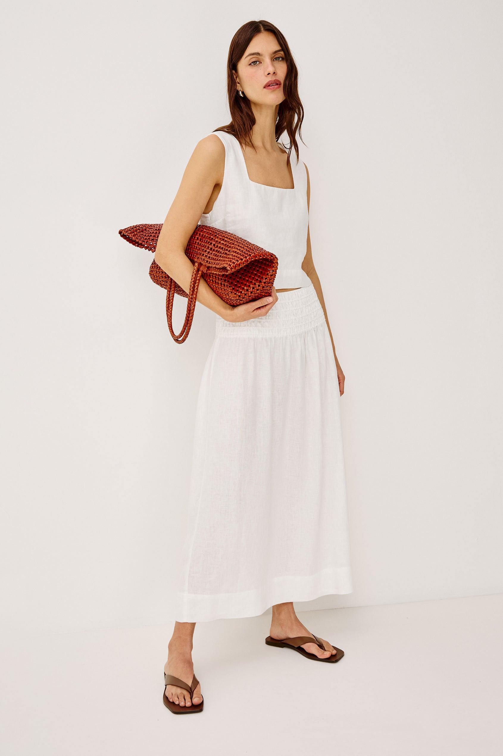 Brava oversized woven tote bag in Cognac brown - full body view of model holding bag in hand