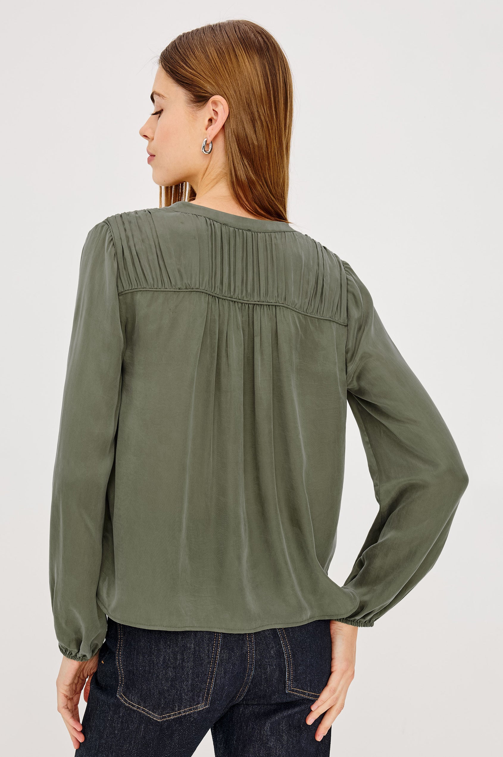 Cadence Shirt in Silky Fabric With Cutaway V-Neck, Shirred Yoke, Front Button Placket, and Slight Puff Long Sleeves and Elastic Cuffs in Washed Olive Colorway - Upper Body Back View Featured on Model