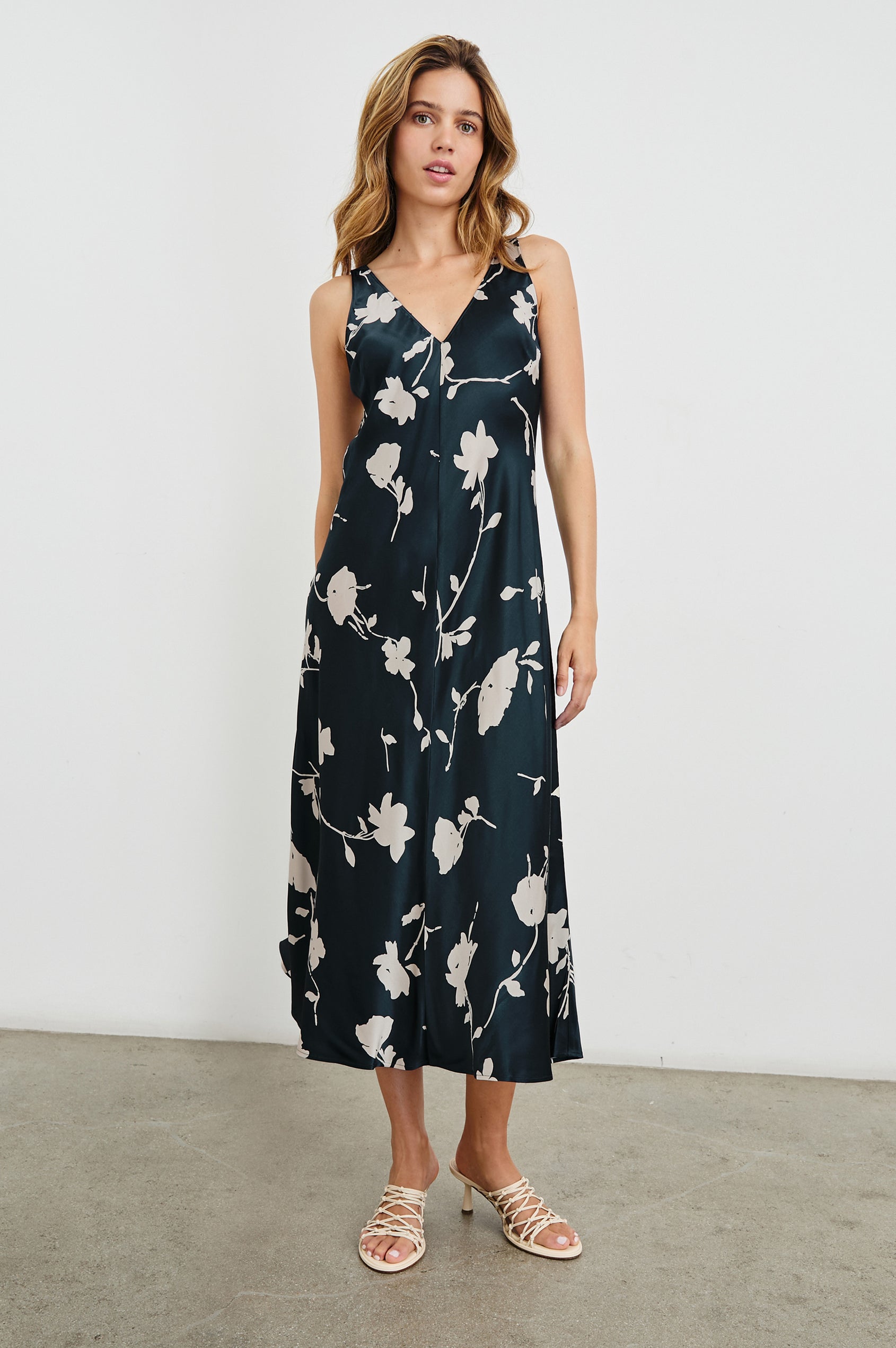 Camellia Sleeveless Midi Dress with Shoulder Straps and a V Neck in Midnight Roses Colorway, with cream flowers on Midnight - Front Full Body View Featured on Model