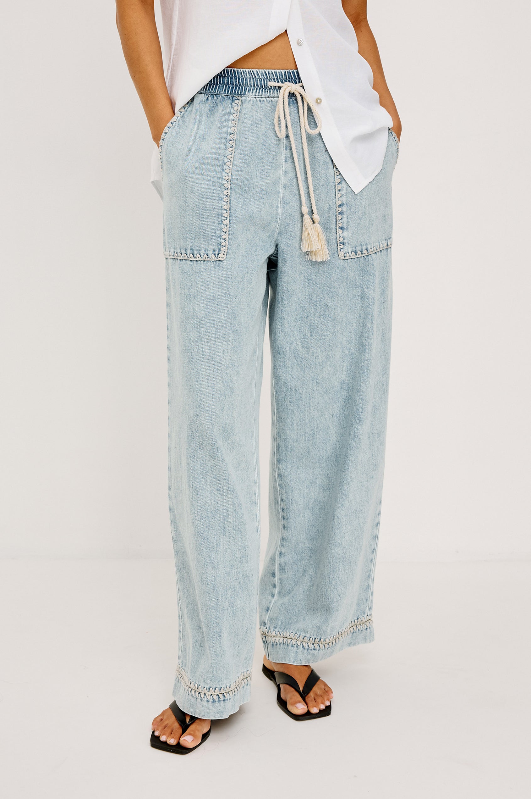 Campo Jean in Cotton Lyocell Denim With Blanket Stitching, Elastic Waist, Side Pockets, and Single Back Pocket in Indigo Blanket Stitch Colorway - Full Body Front View Featured on Model