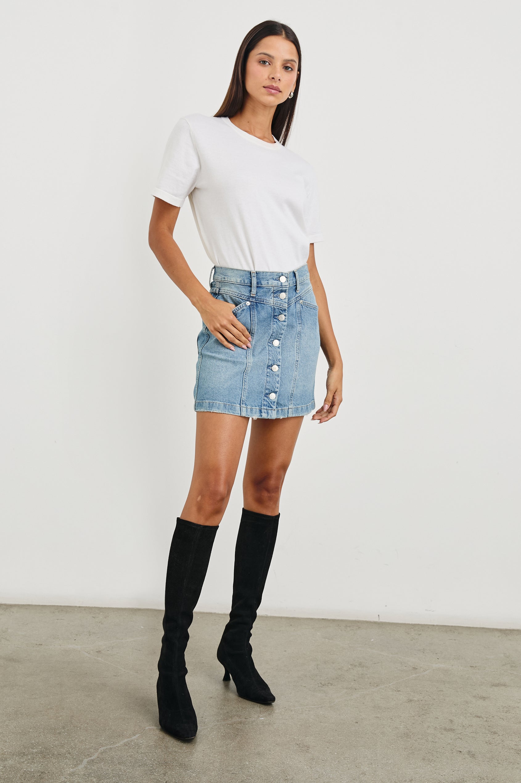 Canyon Denim Mini Skirt with a Full Button Front, Belt Loops, Light Fraying along the Hem, Two Front Pockets and Two Back Patch Pockets in Old Indigo Colorway - Front Full Body View Featured on Model
