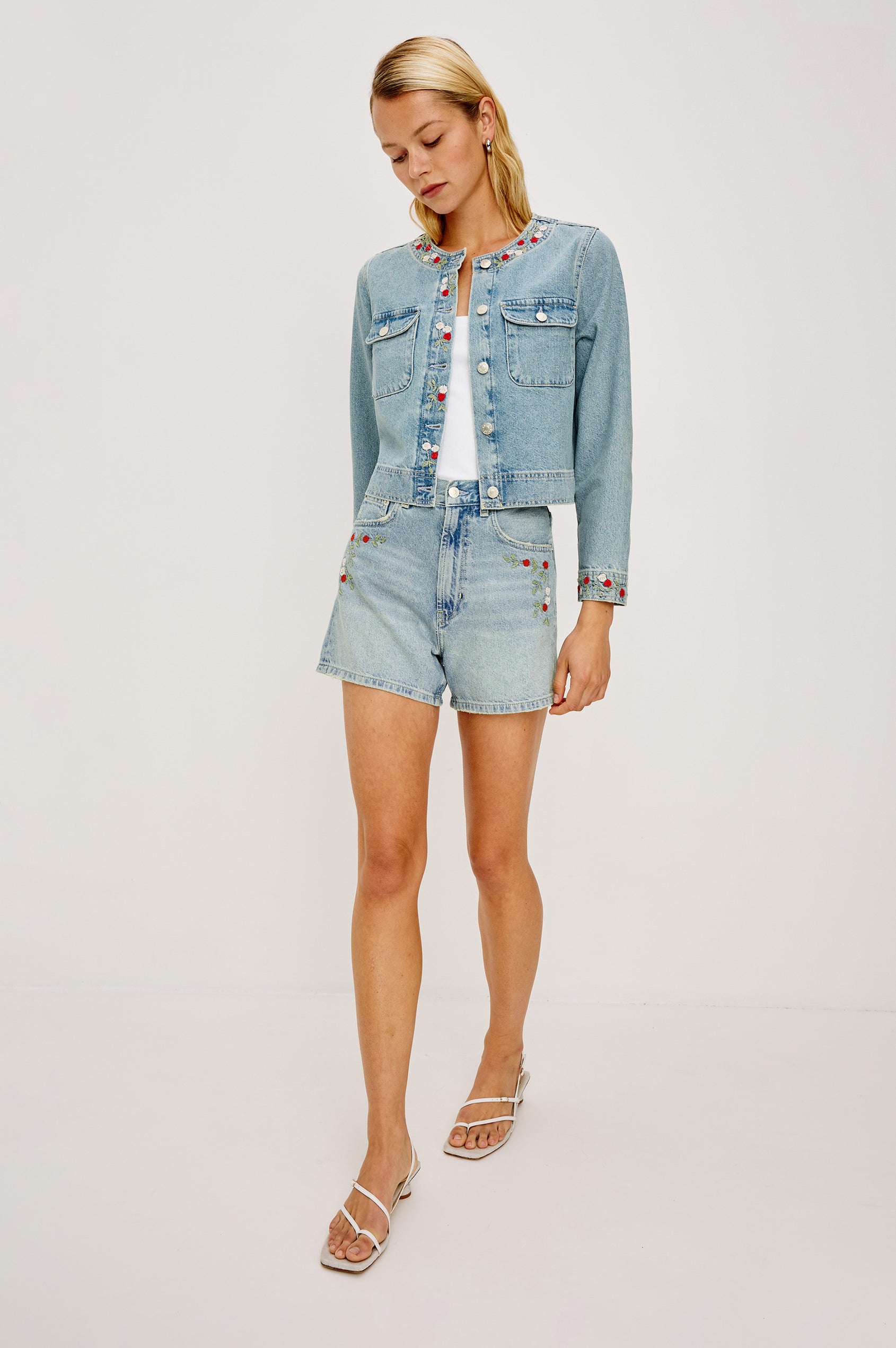 Capistrano Lady Jacket in Recycled Cotton Denim Blend With Floral Embroidery, Chest Flap Buttoned Pockets, and Long Sleeves in Dainty Rose Colorway - Full Body Front View Featured on Model