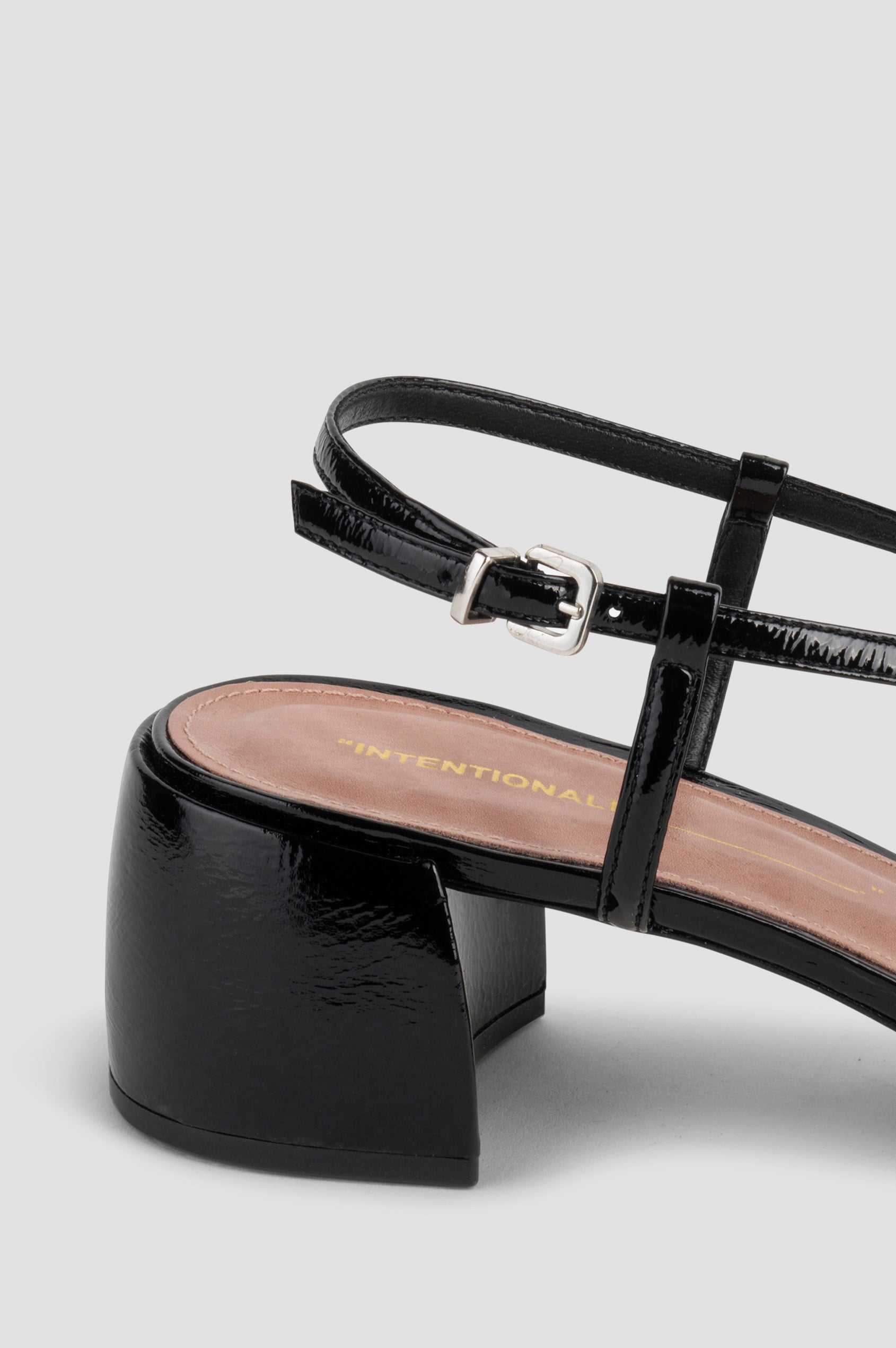 Carina patent leather heel with slingback straps, block heel and front leather bow in Black colorway - close up of ankle strap with buckle