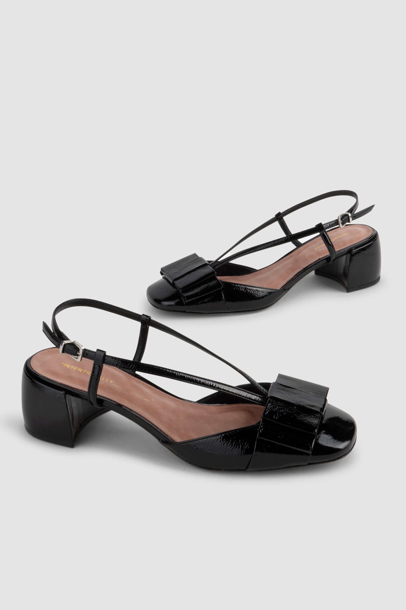 Carina patent leather heel with slingback straps, block heel and front leather bow in Black colorway - cross angle view of shoe pair