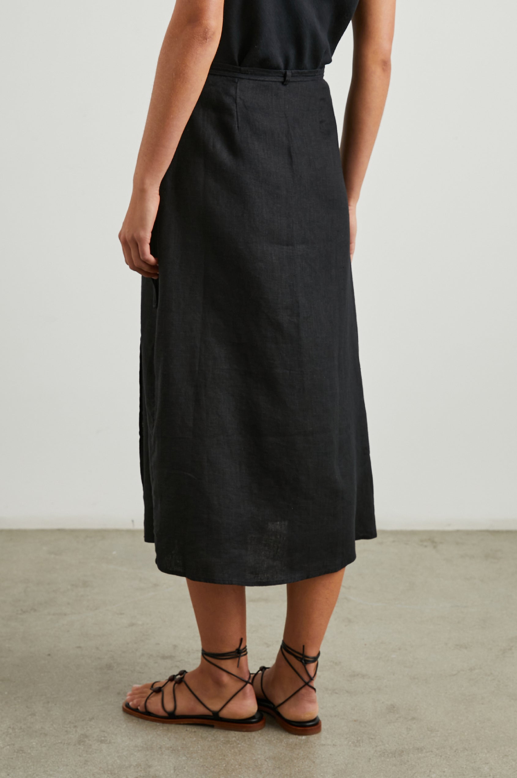 Carly Midi Wrap Skirt With a Side Tie in Black Colorway - Back View Featured on Model 