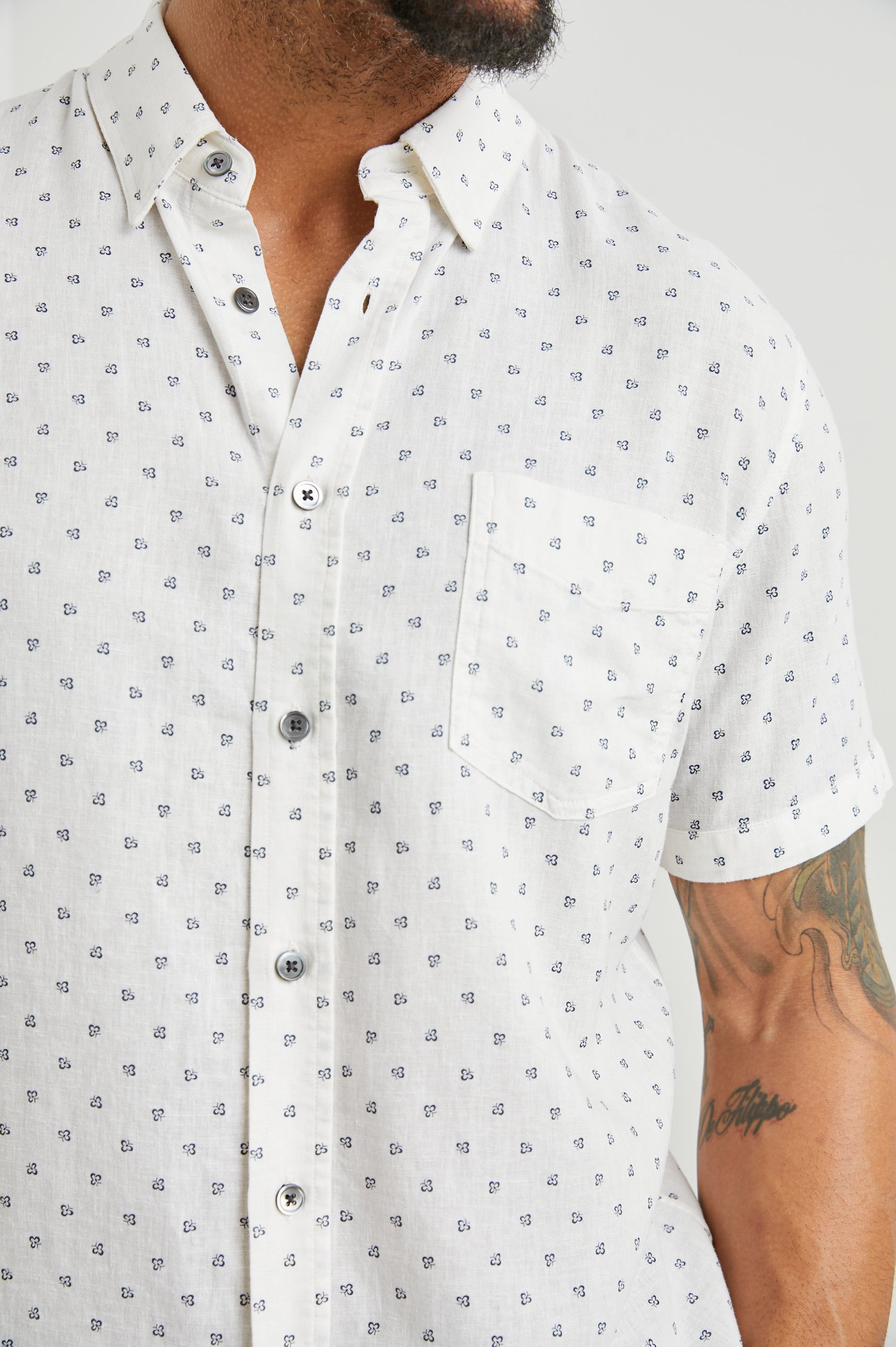 Carson Short Sleeve Button Up with a Chest Patch Pocket in Autumn Calico White Colorway, Small Blue Flowers on White- Front View Featured on Model