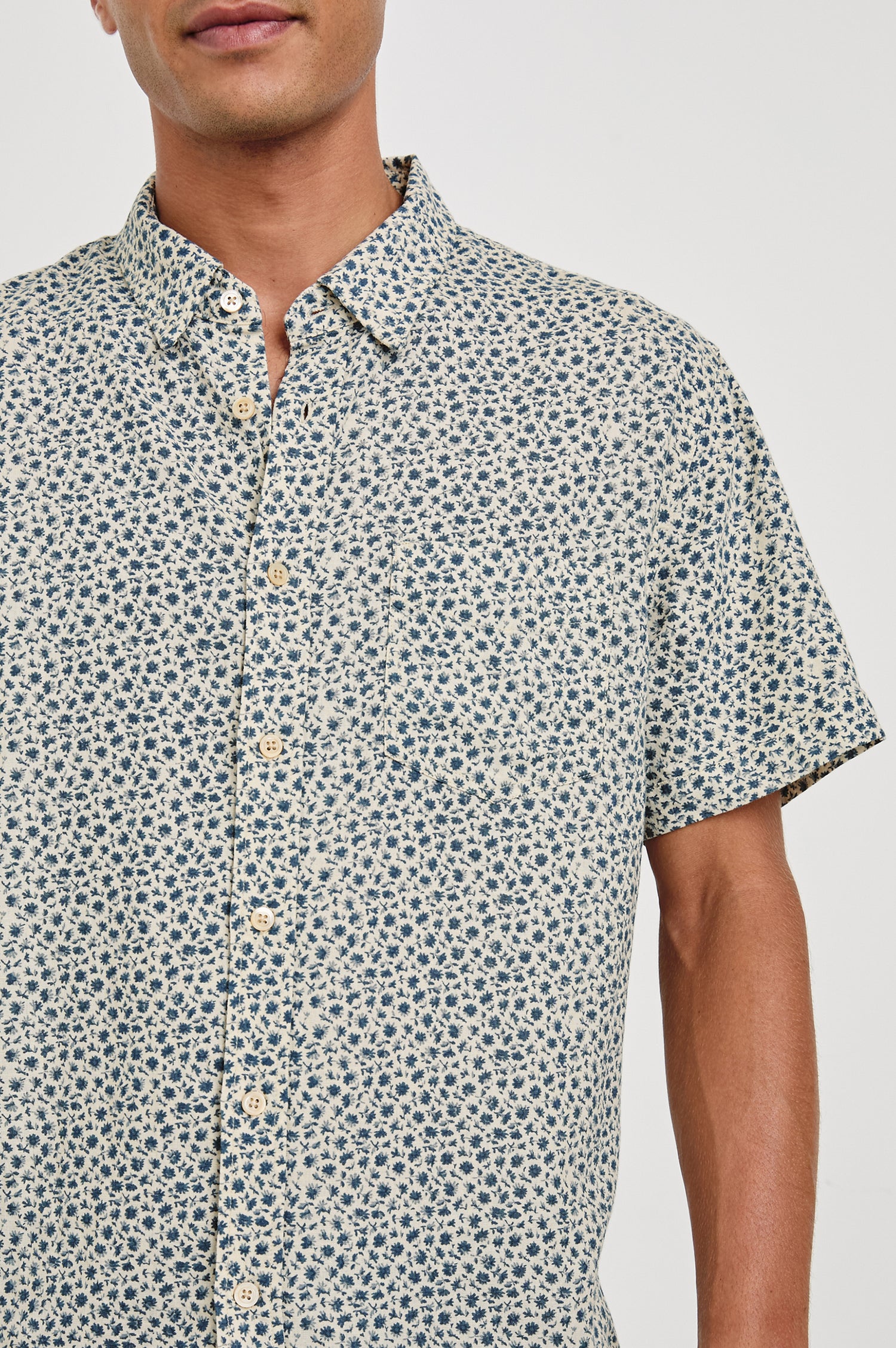 Carson linen short sleeve button down with a collar and blue botanical pattern in Autumn Daisy Ocean - close up of details on model