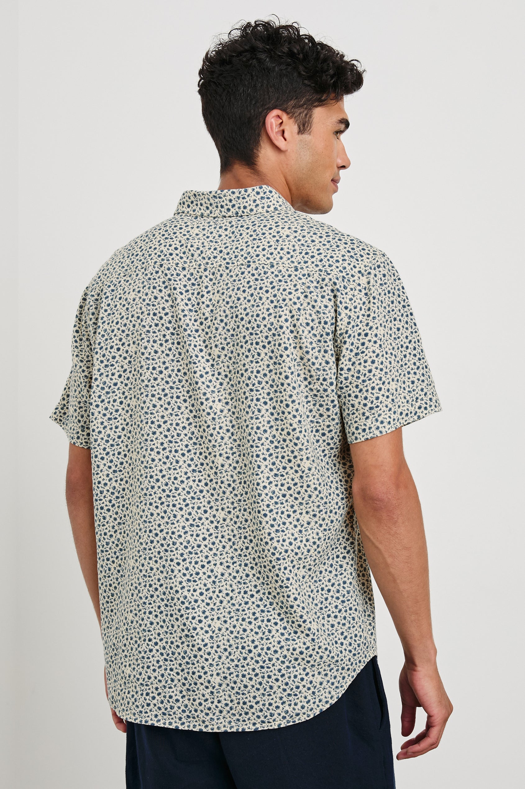 Carson linen short sleeve button down with a collar and blue botanical pattern in Autumn Daisy Ocean - back view on model