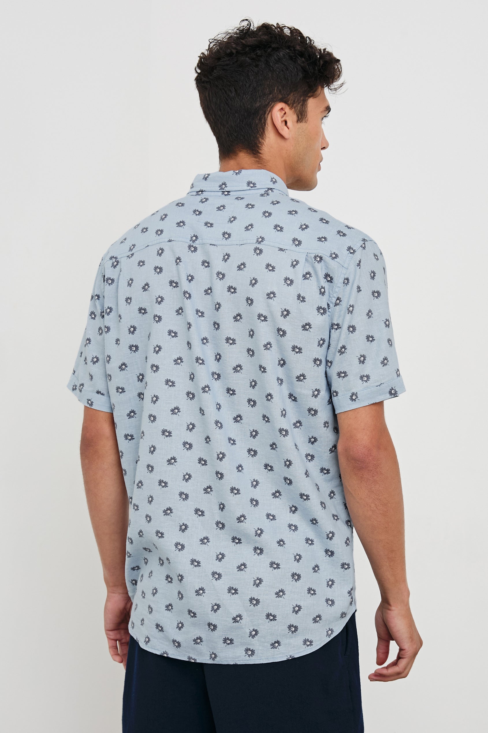 Carson linen short sleeve button down with a collar and floral pattern in Daisy Toss Celestial - back view on model