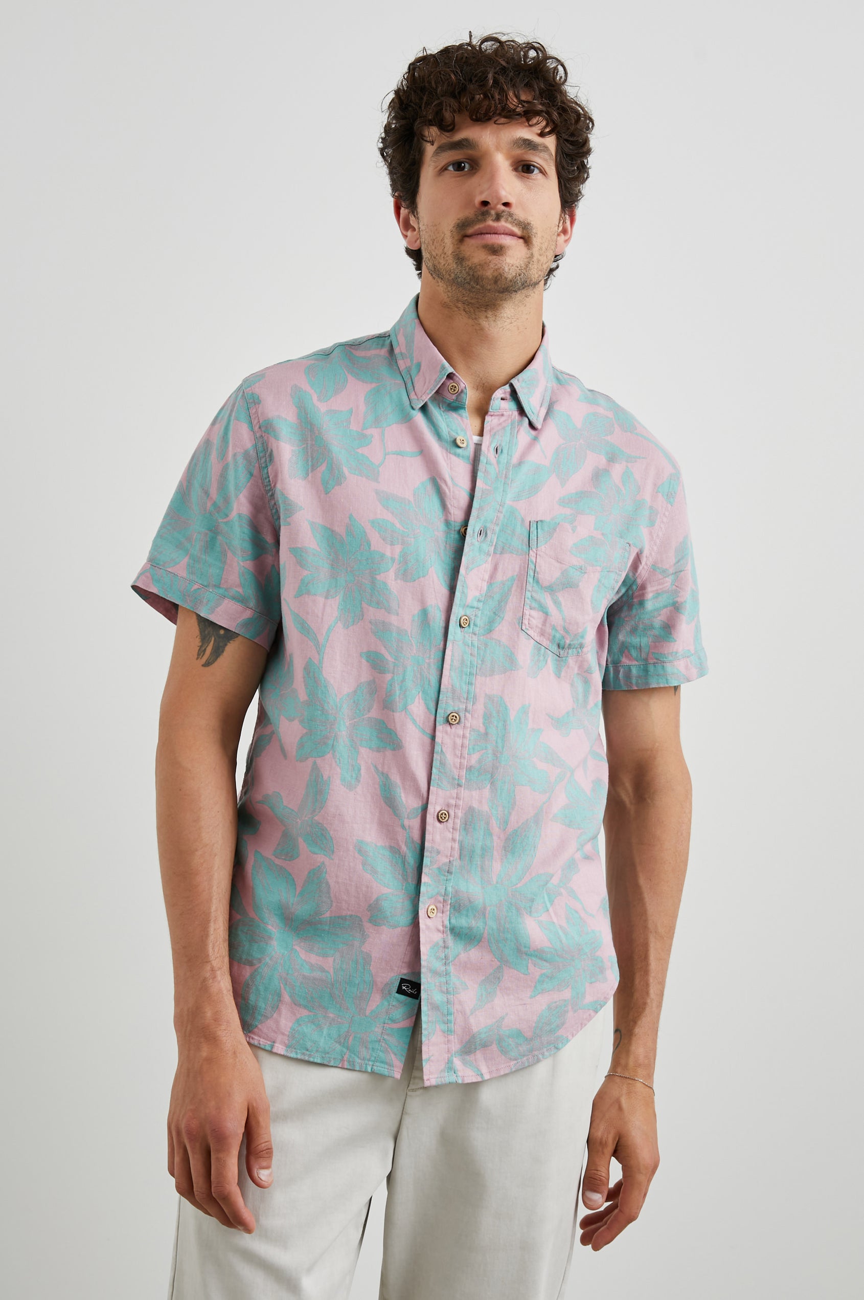Carson Short Sleeve Button Up with a Chest Patch Pocket in Garden Sands Miami Colorway, Green Flowers on Pink - Front View Featured on Model