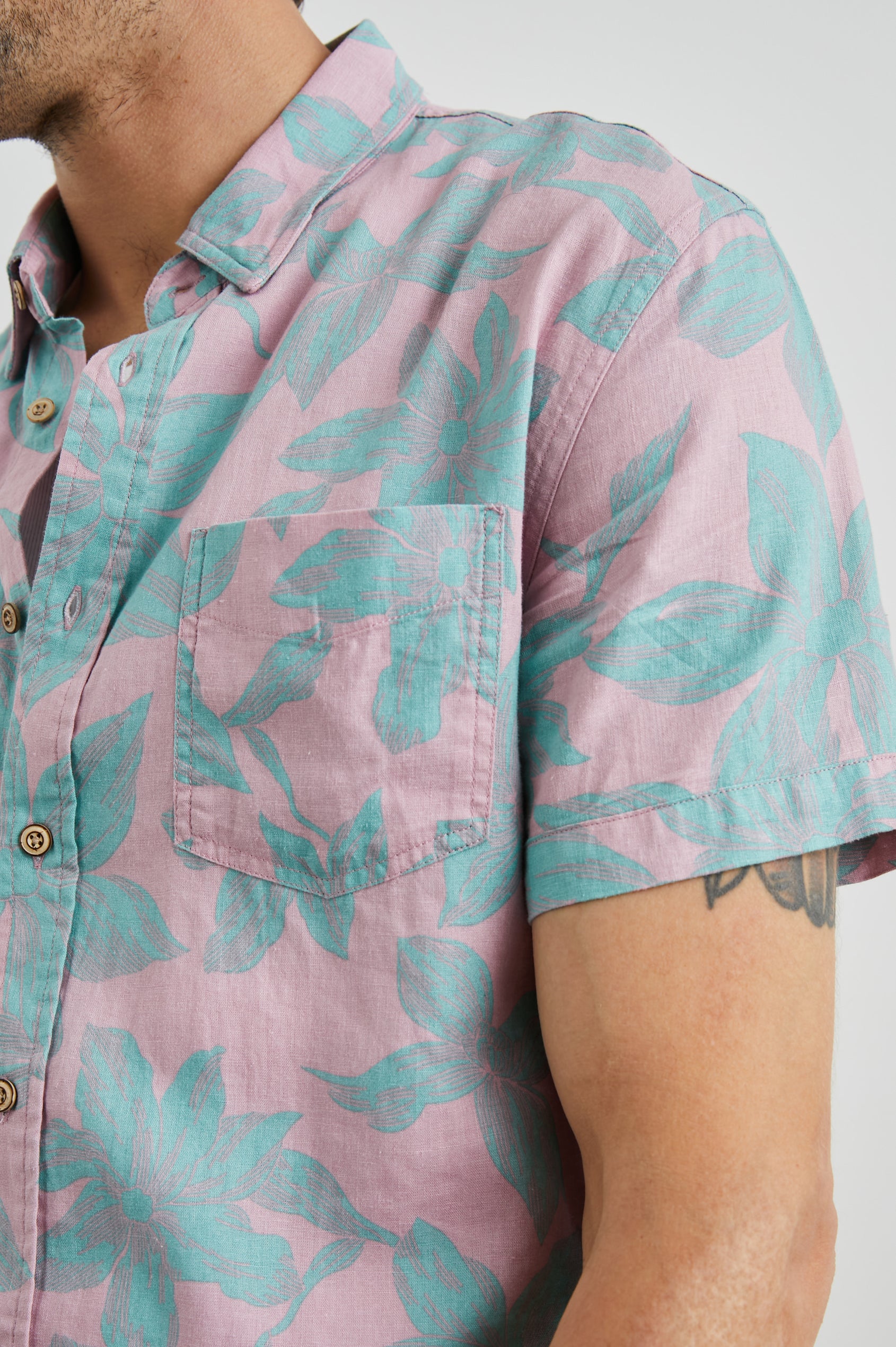 Carson Short Sleeve Button Up with a Chest Patch Pocket in Garden Sands Miami Colorway, Green Flowers on Pink - Front View Featured on Model