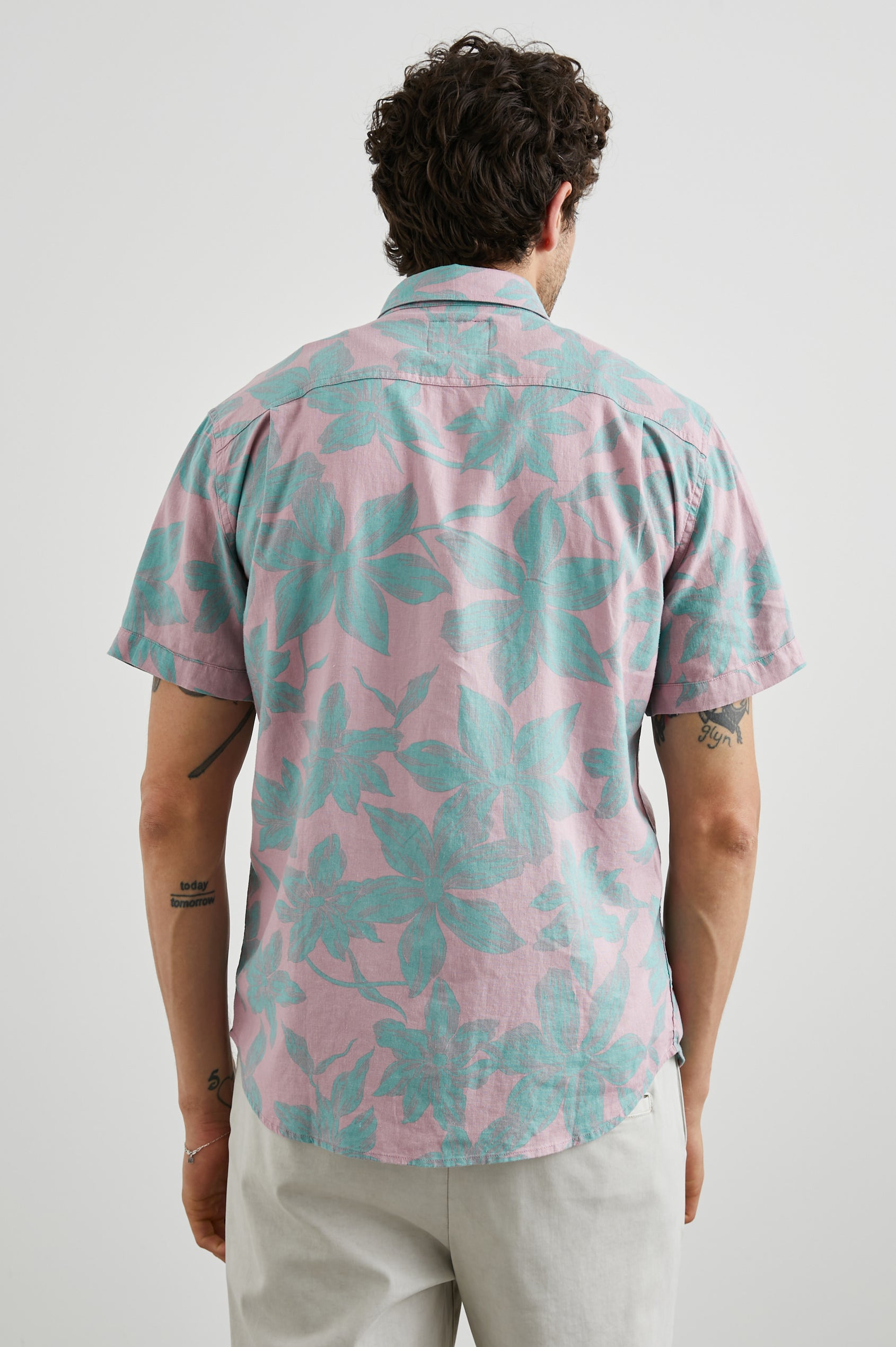 Carson Short Sleeve Button Up with a Chest Patch Pocket in Garden Sands Miami Colorway, Green Flowers on Pink - Back View Featured on Model