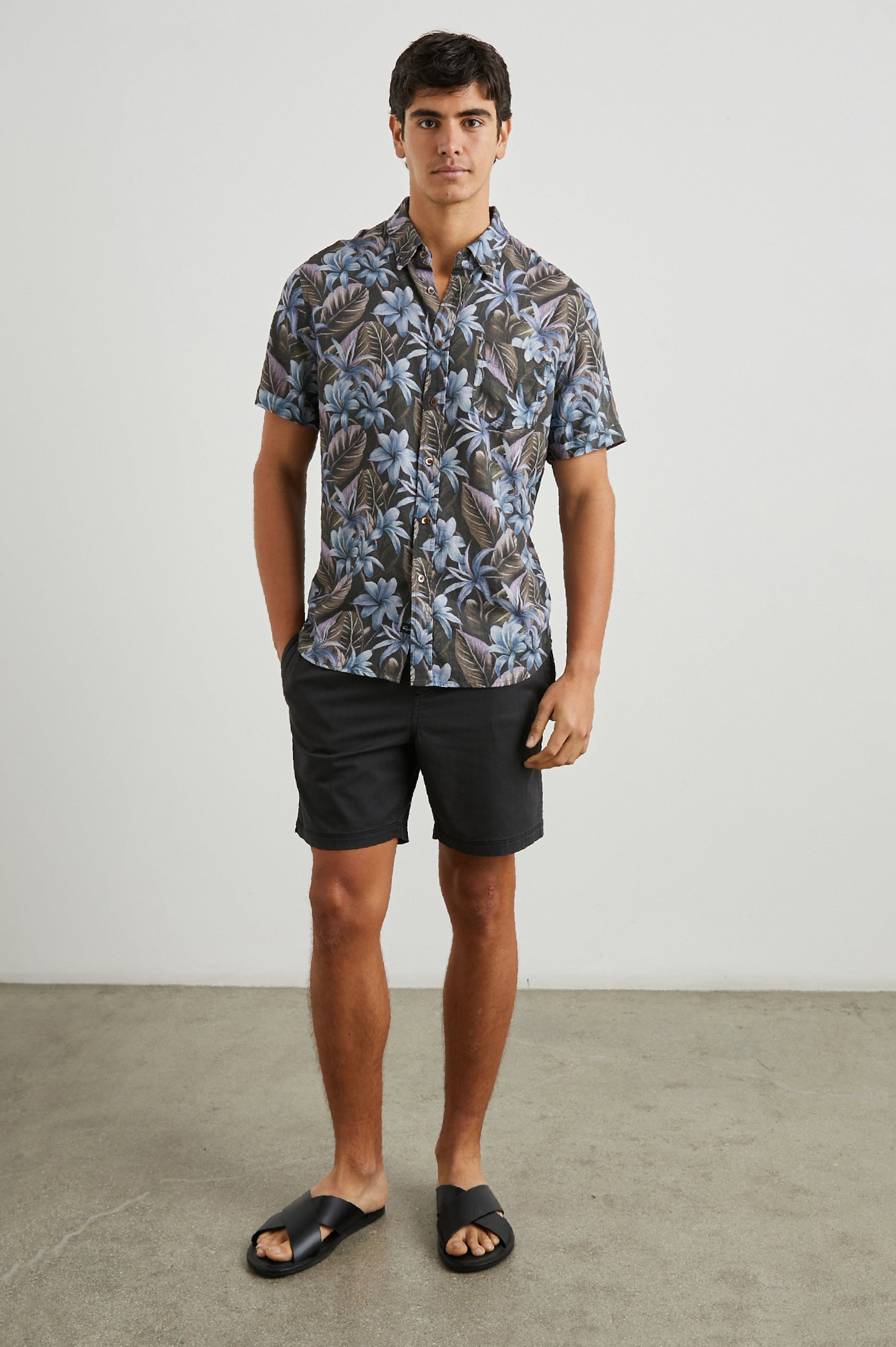 Carson Short Sleeve Button Up with a Chest Patch Pocket in Jungle Garden Midnight Colorway, Flowers and Leaves in Blue and Olive on Midnight - Front Full Body View Featured on Model