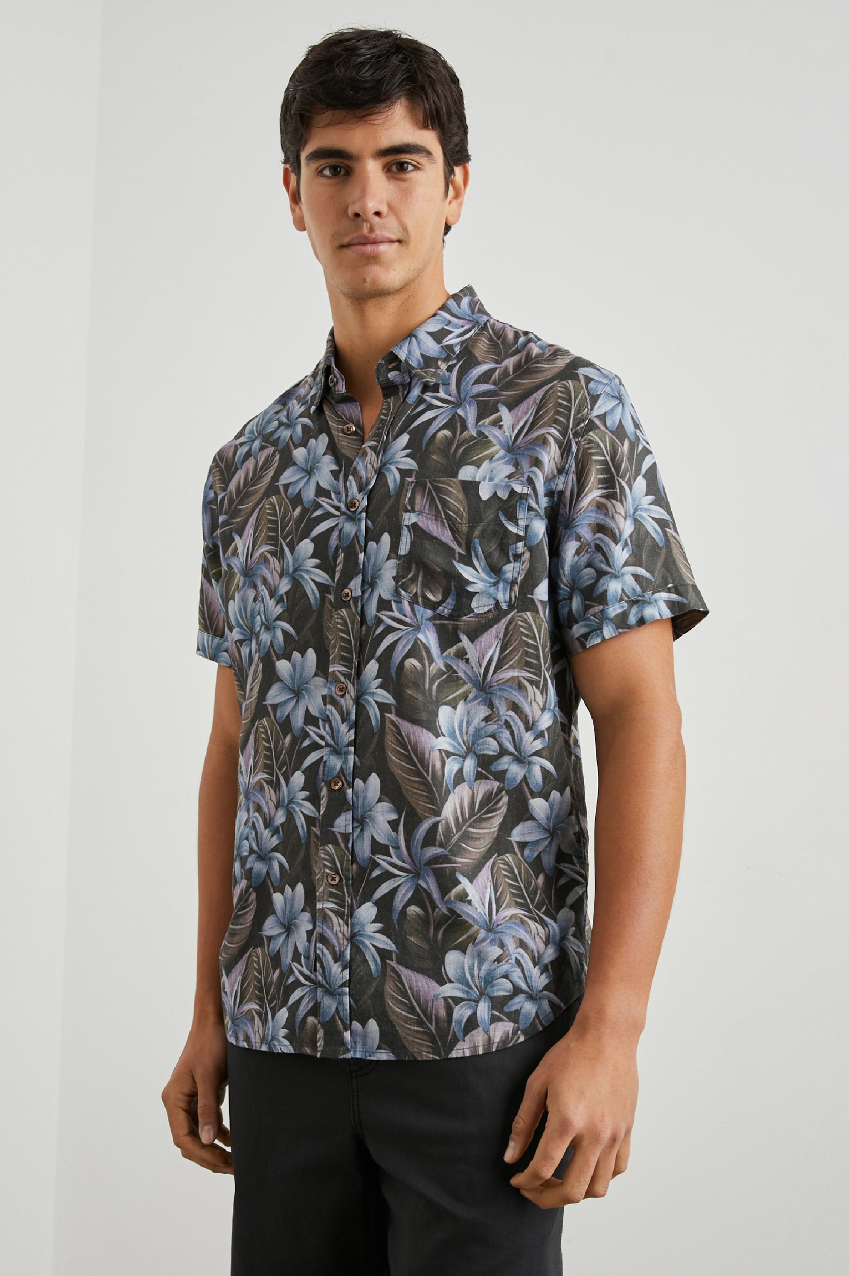 Carson Short Sleeve Button Up with a Chest Patch Pocket in Jungle Garden Midnight Colorway, Flowers and Leaves in Blue and Olive on Midnight - Front View Featured on Model