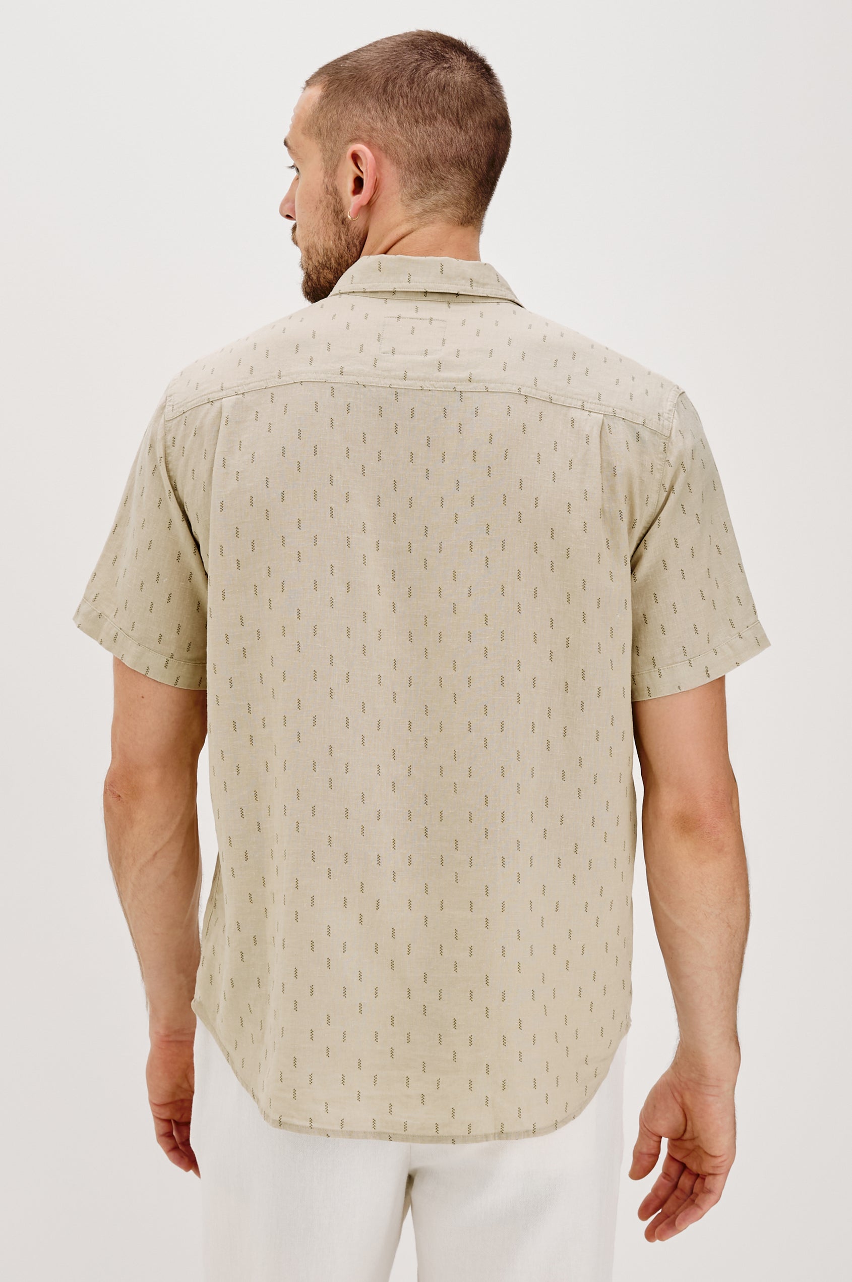 Carson linen short sleeve button down with a collar and front chest pocket in Louis Leaf Khaki colorway - back view on model