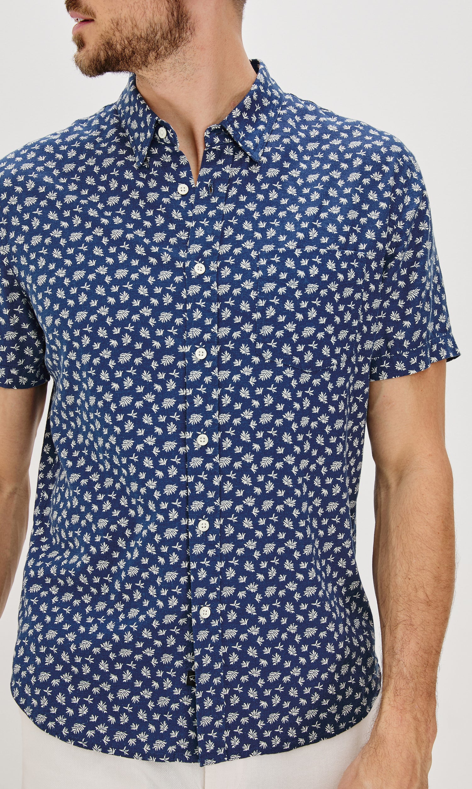 Carson Collared Button Front Shirt with Short Sleeves and a Chest Pocket in Nervous Leaf Blue Colorway. Front View Shown on Model.