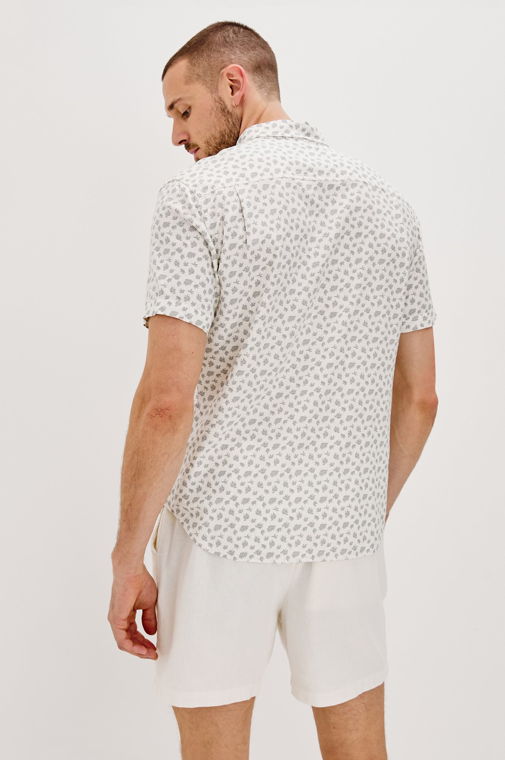 Carson Collared Button Front Shirt with Short Sleeves and a Chest Pocket in Nervous Leaf White Colorway. Back View Shown on Model.