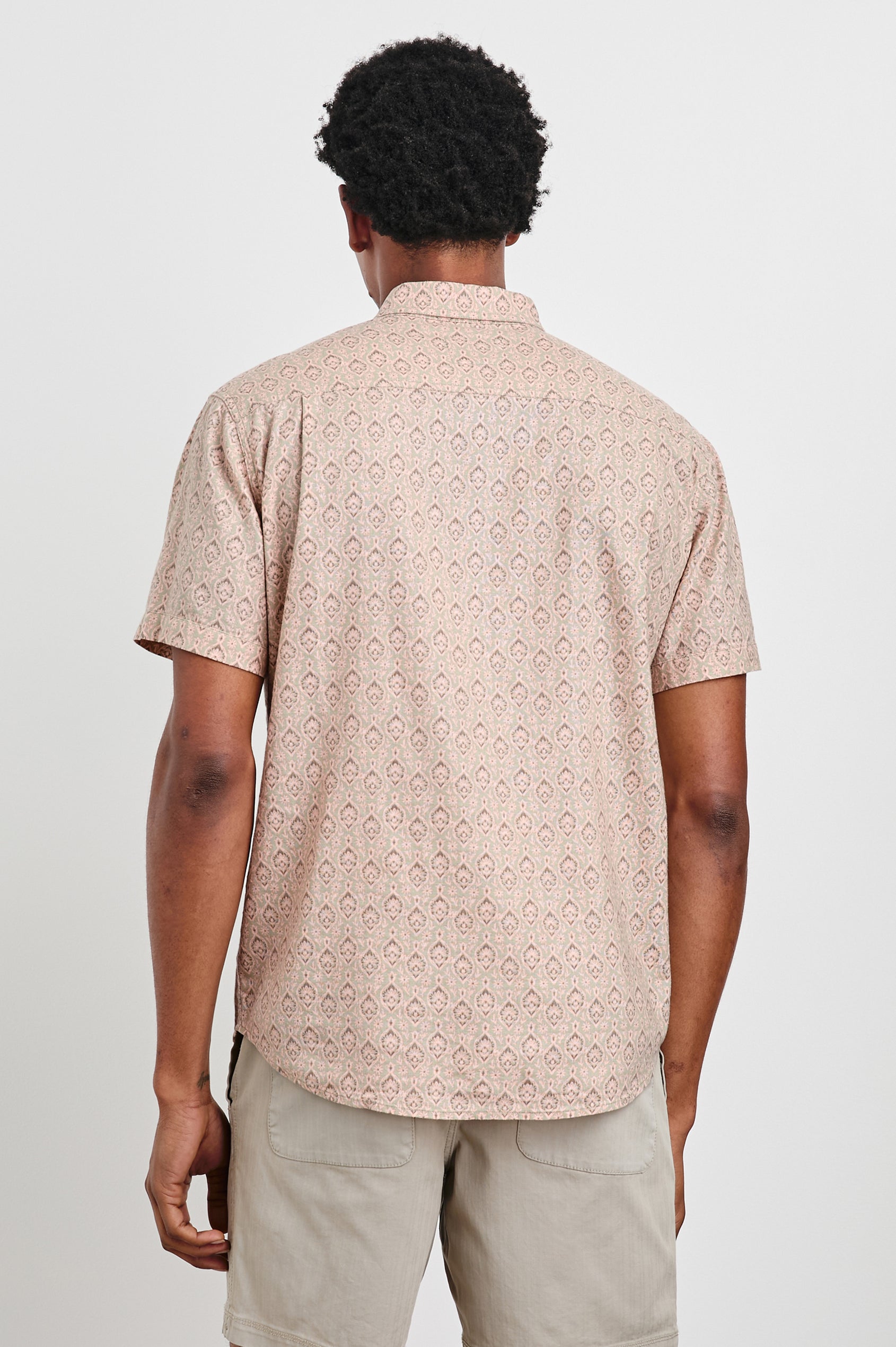 Carson linen short sleeve button down with a collar and ornamental pattern in Batik Flamingo - back view on model