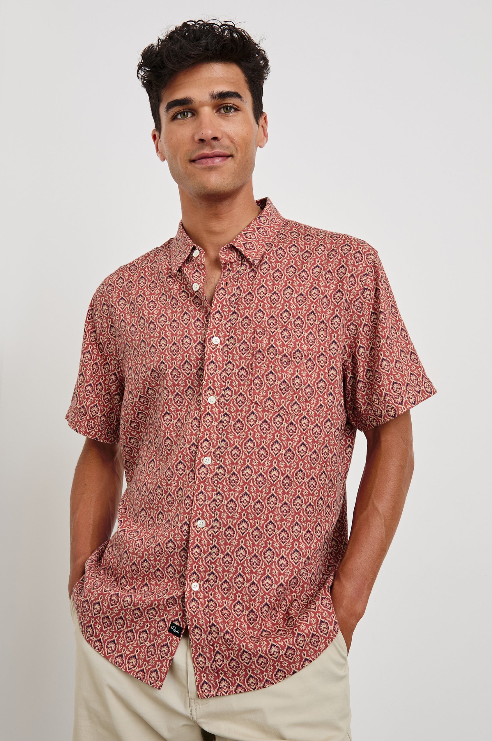 Carson linen short sleeve button down with a collar and ornamental pattern in Batik Rose - front view on model, hands in pocket