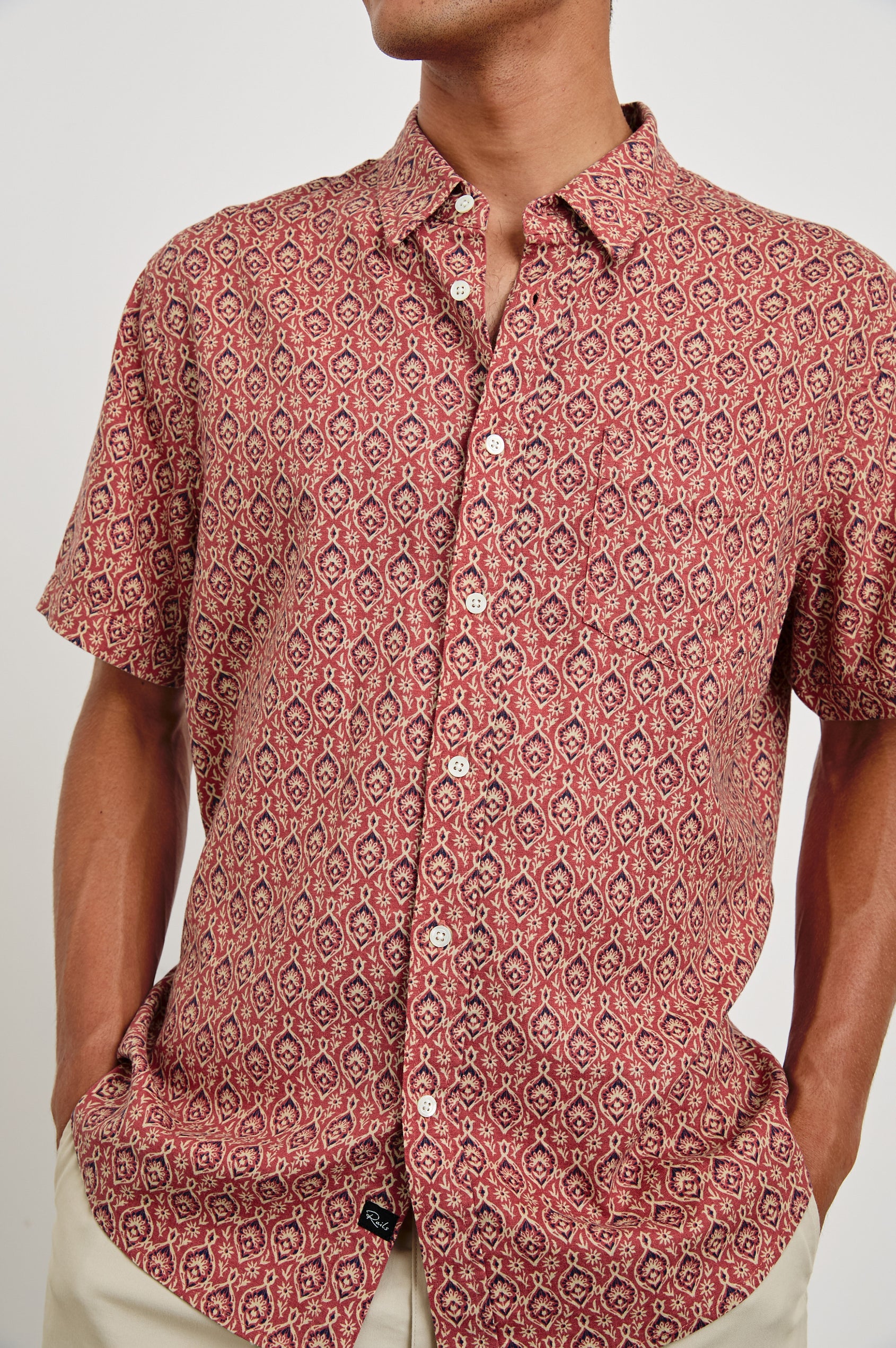 Carson linen short sleeve button down with a collar and ornamental pattern in Batik Rose - close up of details on model