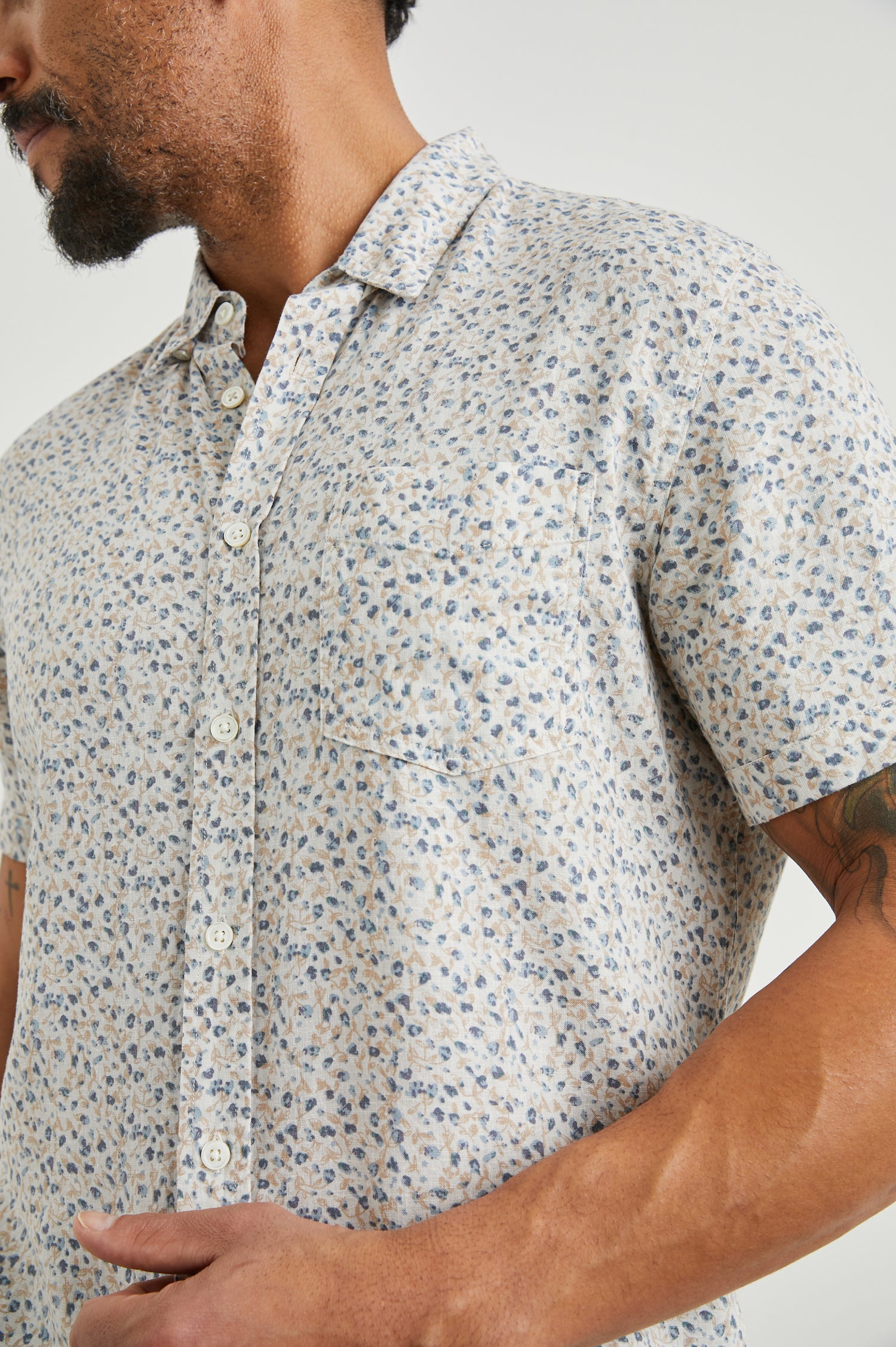 Carson Short Sleeve Button Up with a Chest Patch Pocket in Spring Blossom Parchment Colorway, Blossoms in Blue and Tan on Parchment - Front View Featured on Model