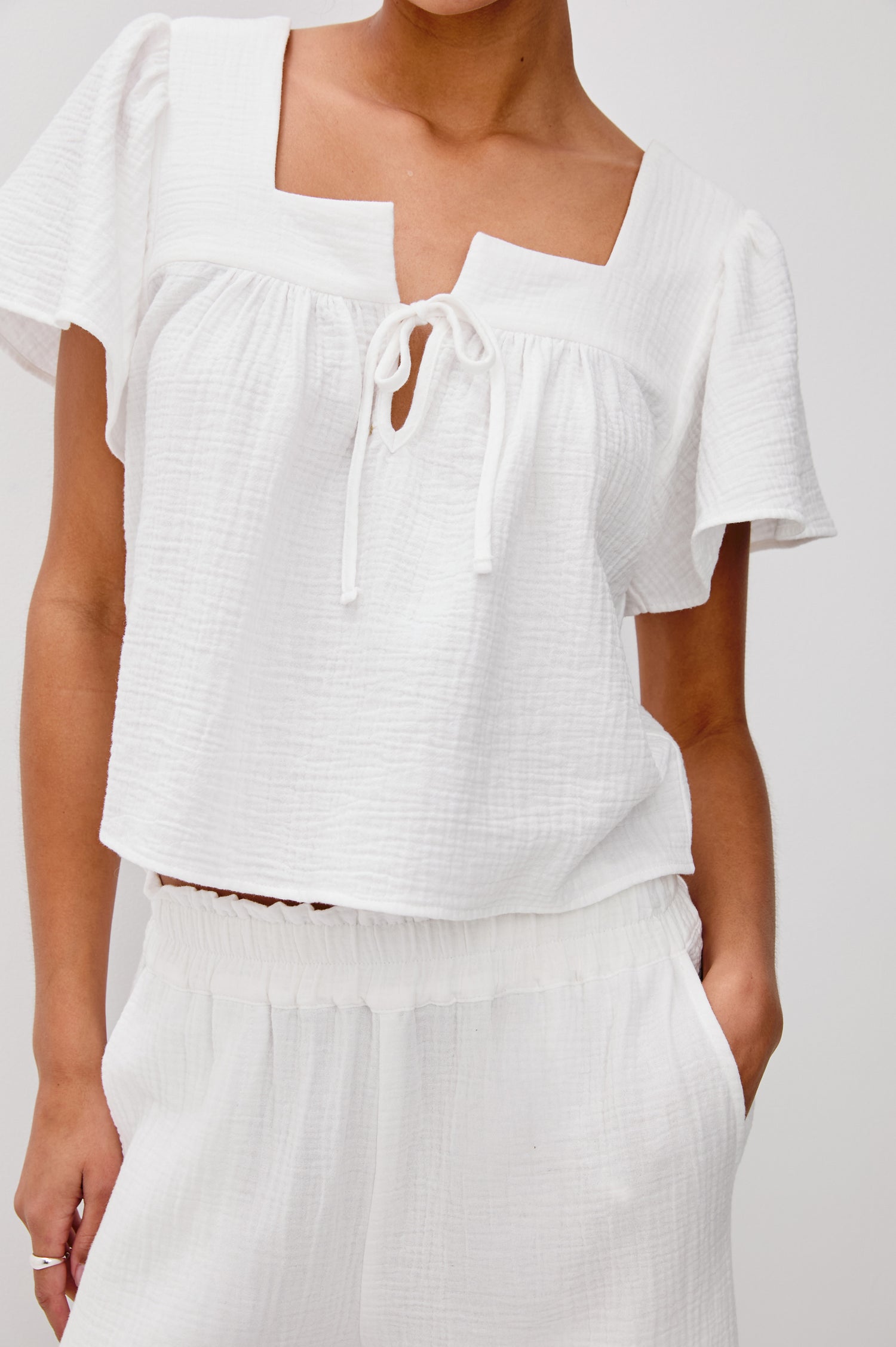 Casie Square Neck Flutter Sleeve Top with a V-Tie Front in White Colorway. Front Detailed View Shown on Model.