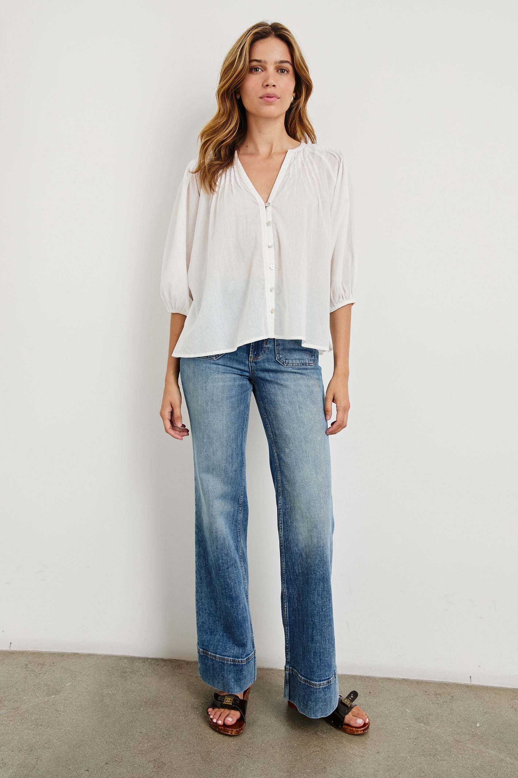 Cassat Blouse with a Deep V-Neckline, Mid-Length Sleeves with Elastic Openings and Pleating around Neckline in White Colorway - Front Untucked Full Body View Featured on Model