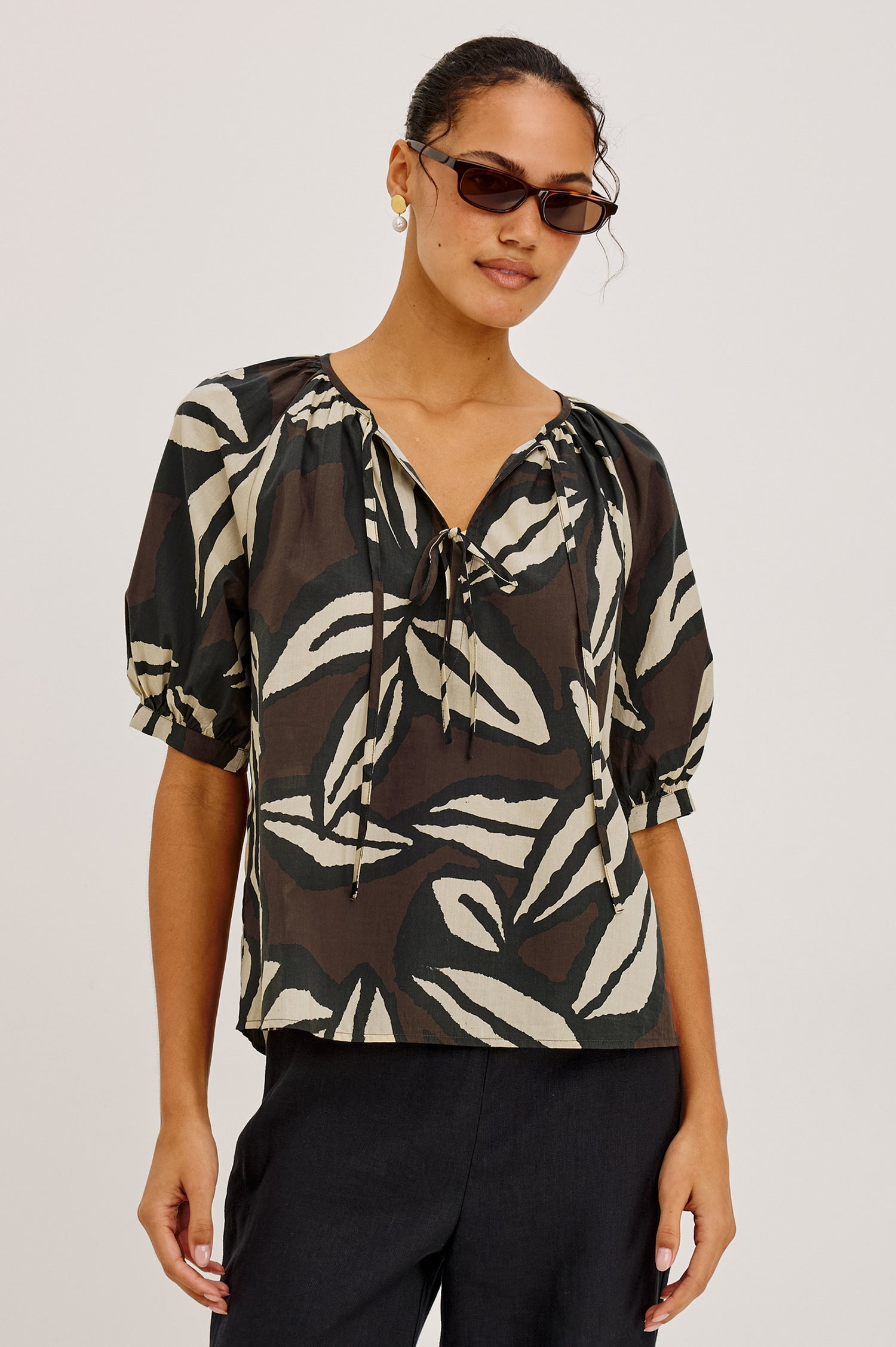 Catalene Peasant Blouse in Cotton Voile With Self-Tie V-Neckline, Loose Fit, and Short Puff Sleeves in Cocoa Floral Colorway - Upper Body Front View Featured on Model