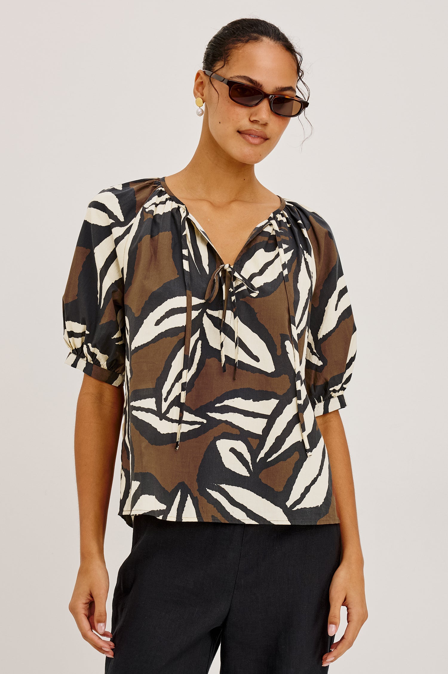 Catalene Peasant Blouse in Cotton Voile With Self-Tie V-Neckline, Loose Fit, and Short Puff Sleeves in Cocoa Floral Colorway - Upper Body Front View Featured on Model