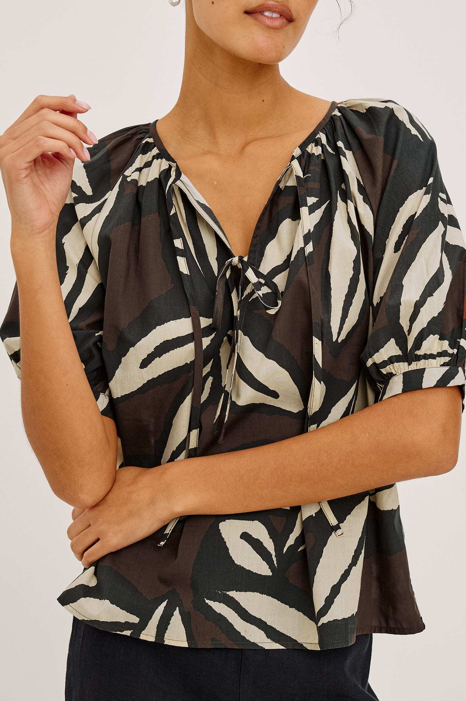 Catalene Peasant Blouse in Cotton Voile With Self-Tie V-Neckline, Loose Fit, and Short Puff Sleeves in Cocoa Floral Colorway - Upper Body Close Up Front View Featured on Model
