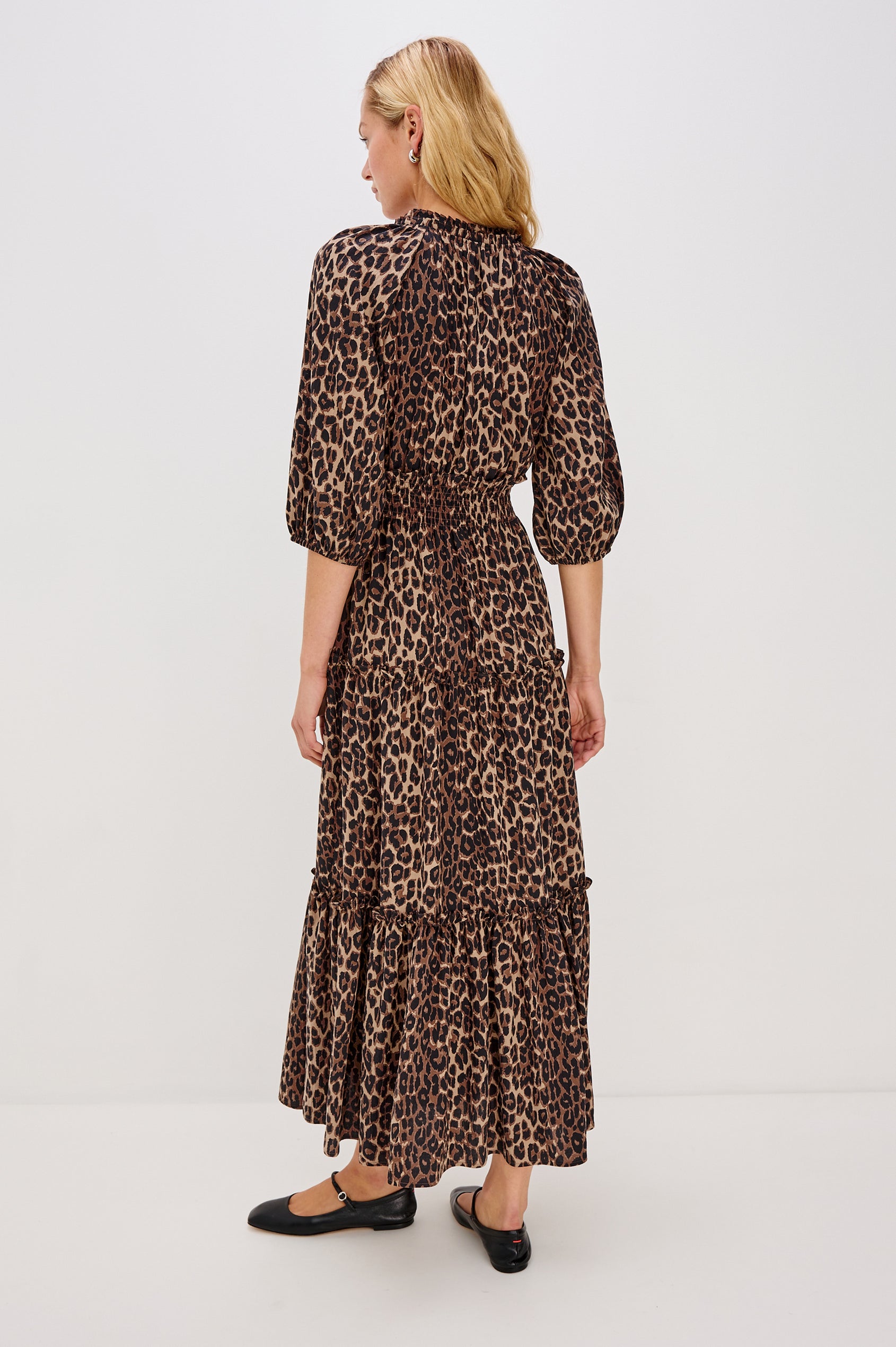 Caterine Maxi Dress with Mid-length Sleeves, a V neck, a Shirred Collar with a tie, a Smocked Waist, and a Tiered Skirt in Brown Nala Colorway - Back View Featured on Model