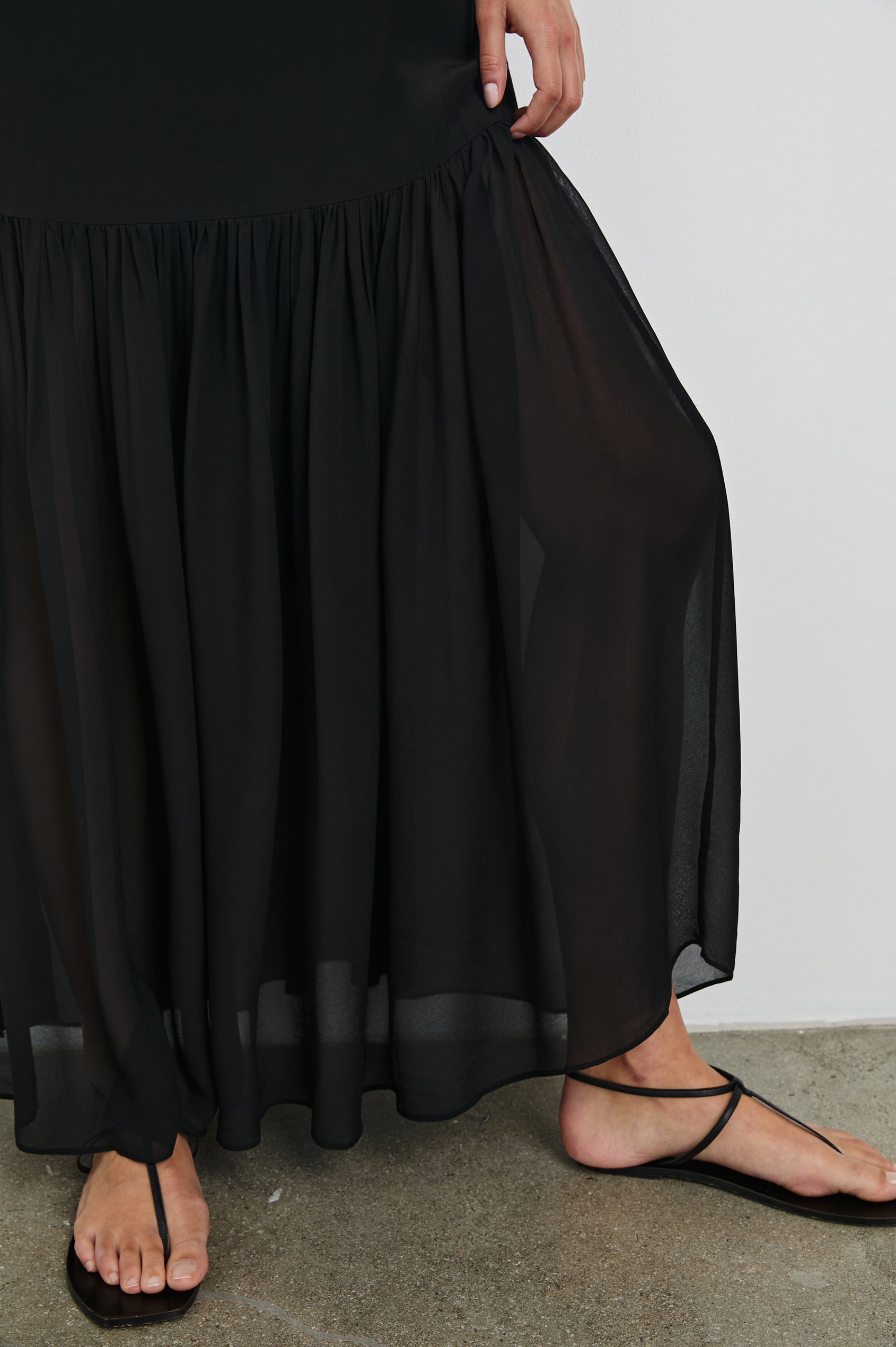Chandra Maxi Tank Dress with Spaghetti Straps and a Contrast Semi Sheer Fabric Gathered Hem in Black Colorway. Front Detailed View Shown on Model.