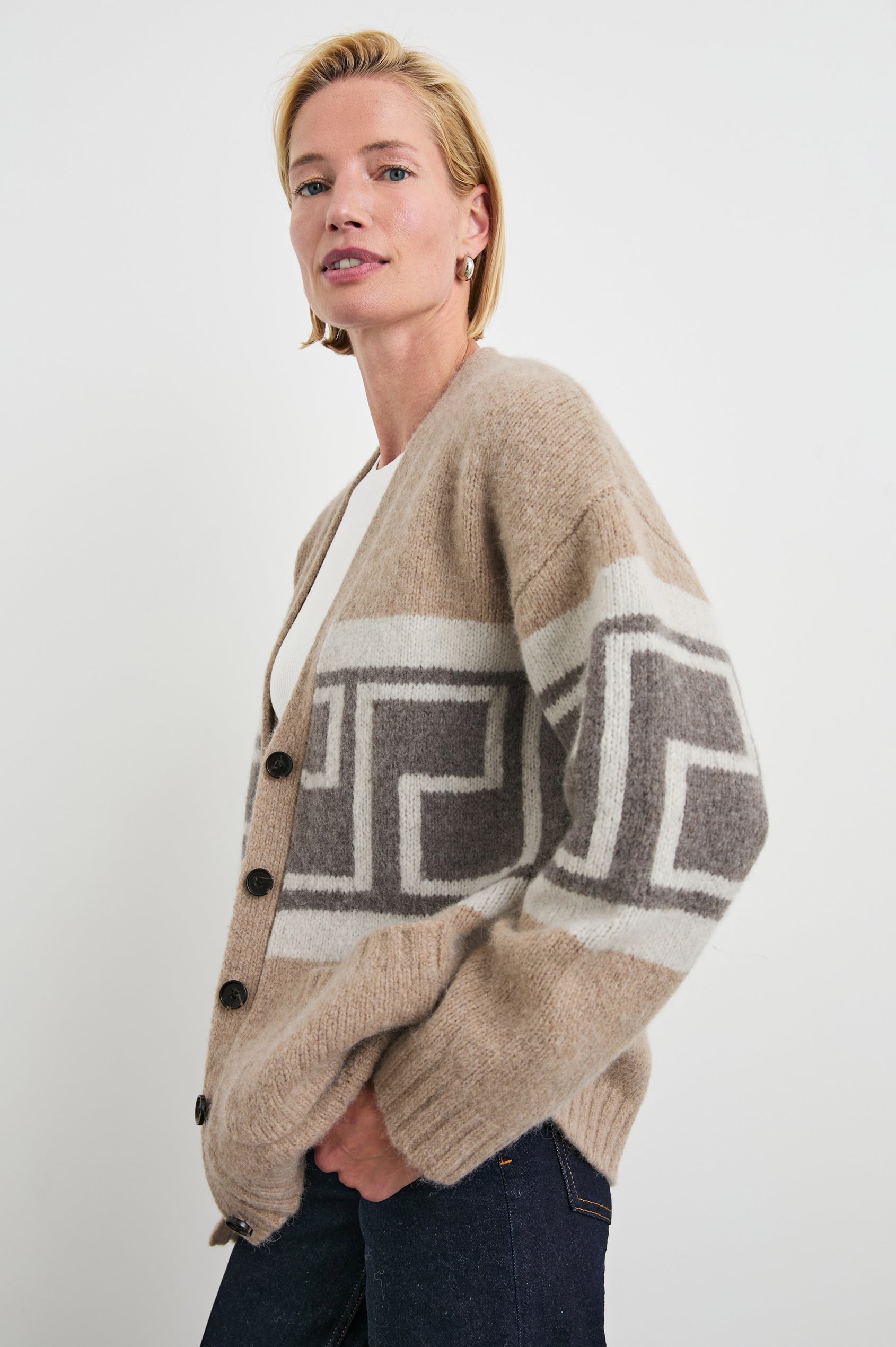 Chelsea Long-Sleeve Cardigan with Button Closure, Two Front Patch Pockets, Ribbed Trim and a Deep V Neck in Aspen Trail Colorway, a Grey and White Geometric Pattern on Oatmeal - Side View Featured on Model