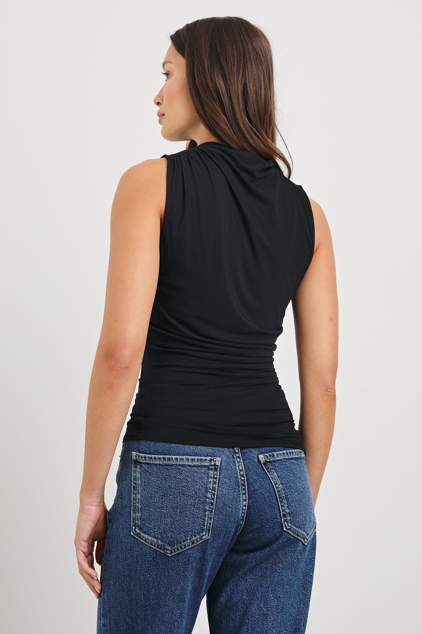 Christen Sleeveless Top with a Mock Neck and Ruching Along One Side Seam in Black Colorway - Back View Featured on Model